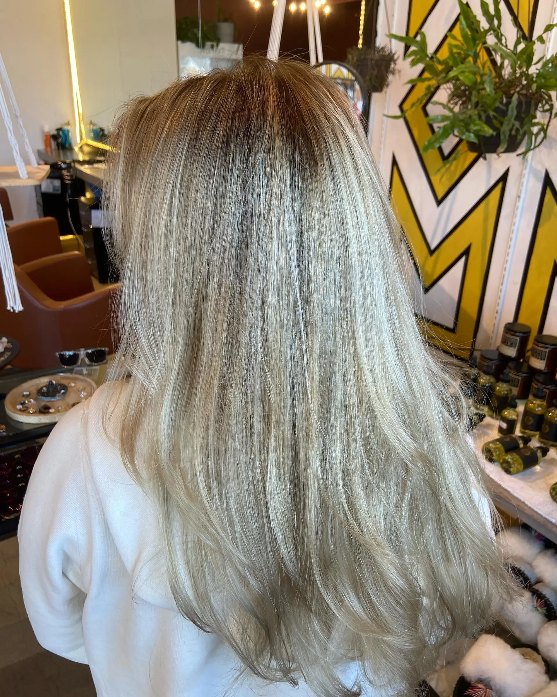 Long, flowing ash blonde hair styled straight with soft layers and dimensional full highlights seamlessly blended with a natural shadow root. 1