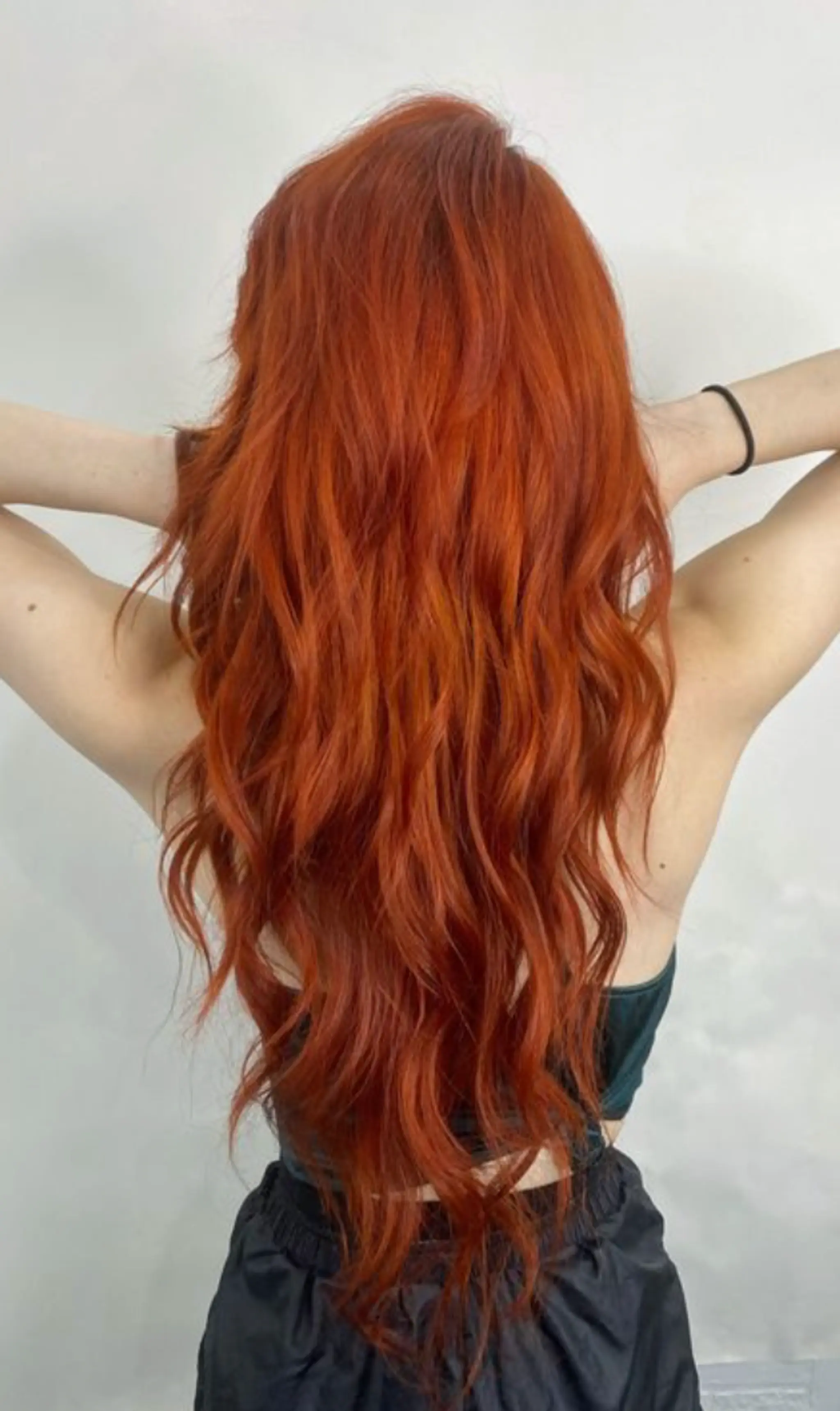 Very long, wavy hair with layers and a vibrant red color, featuring natural and loose waves.