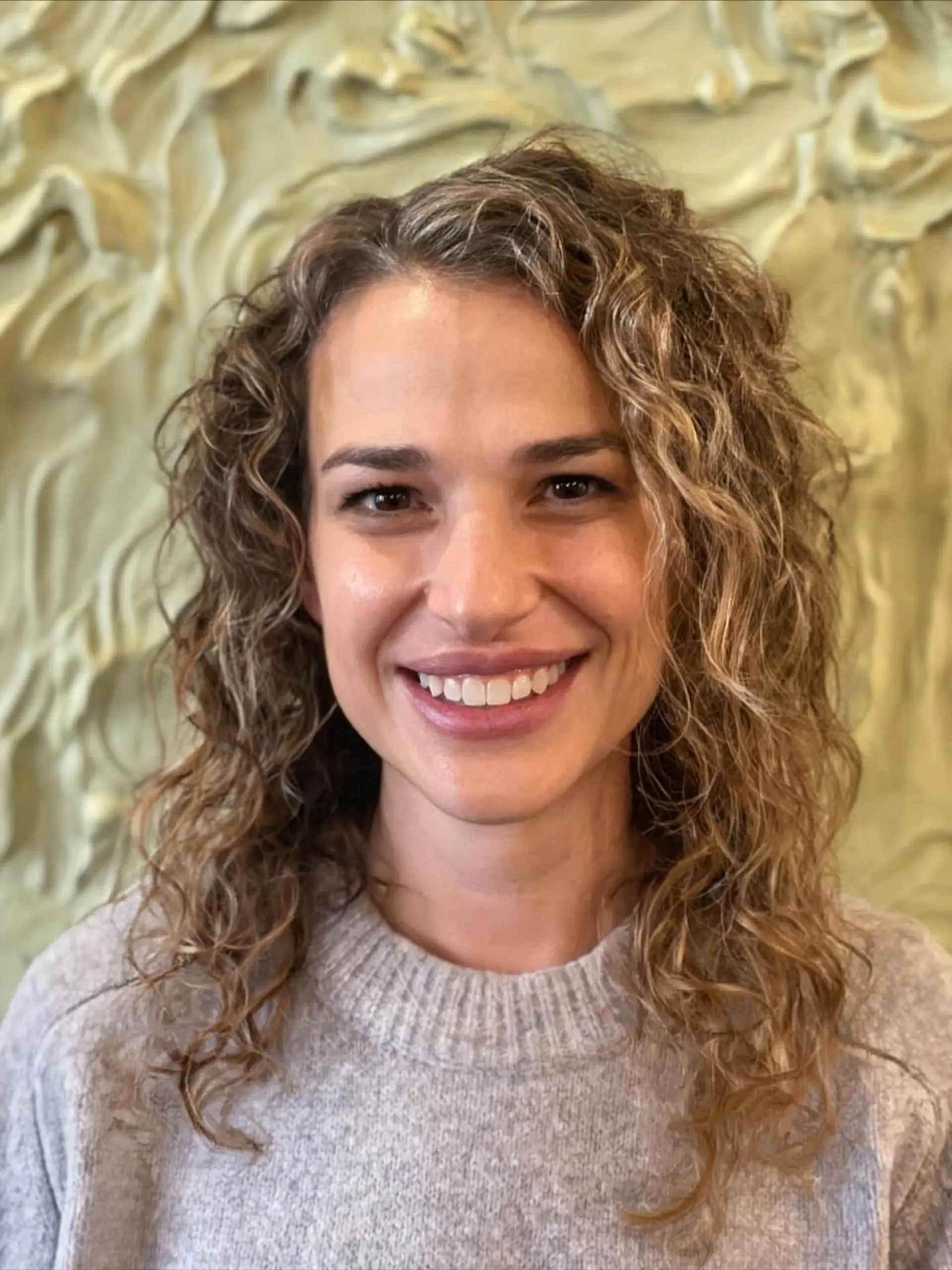 Shoulder-length curly hair styled with soft, diffused ringlets and luminous golden blonde highlights. 1