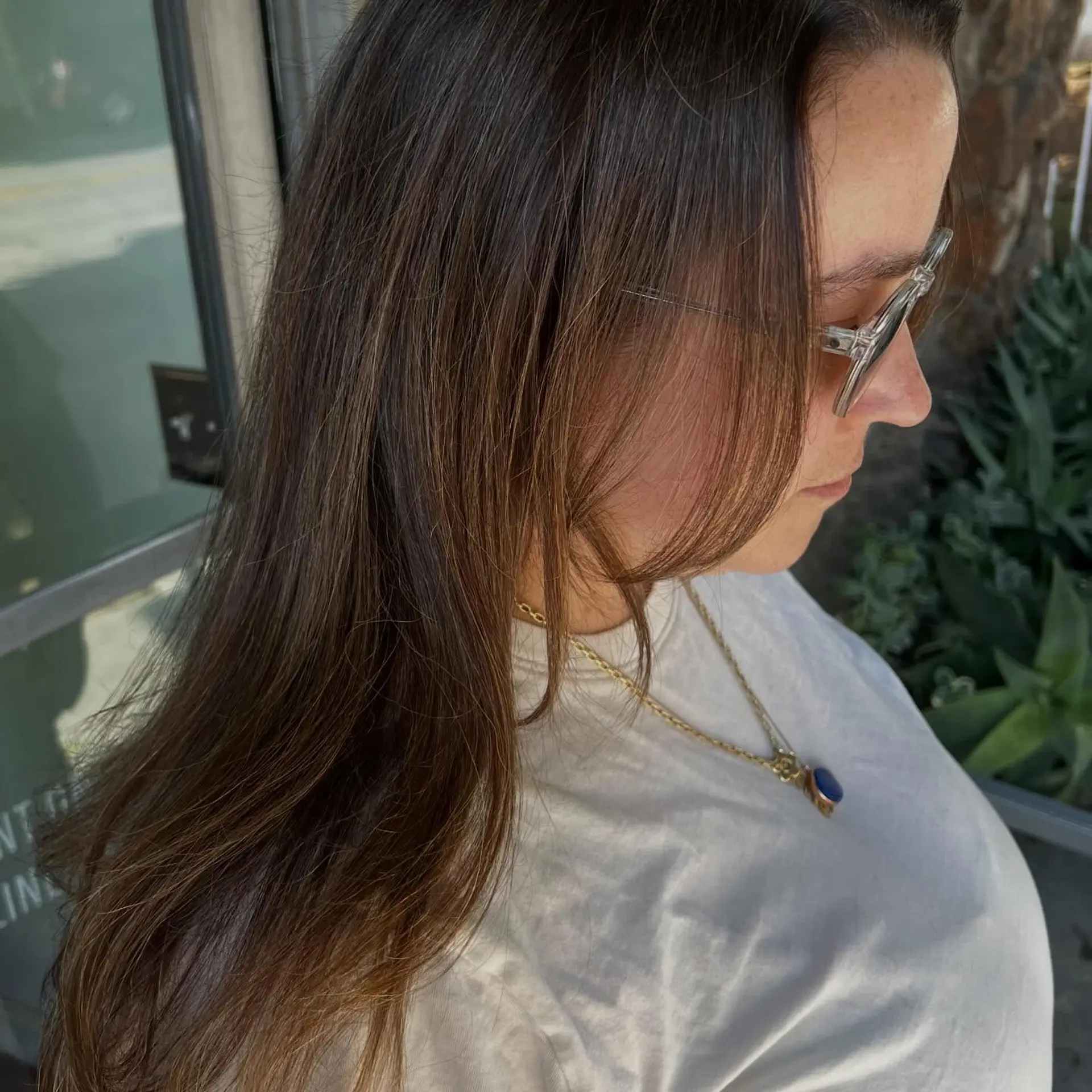 Long, naturally straight brunette hair with seamless, low-maintenance dimensional blending and soft face-framing pieces. 1