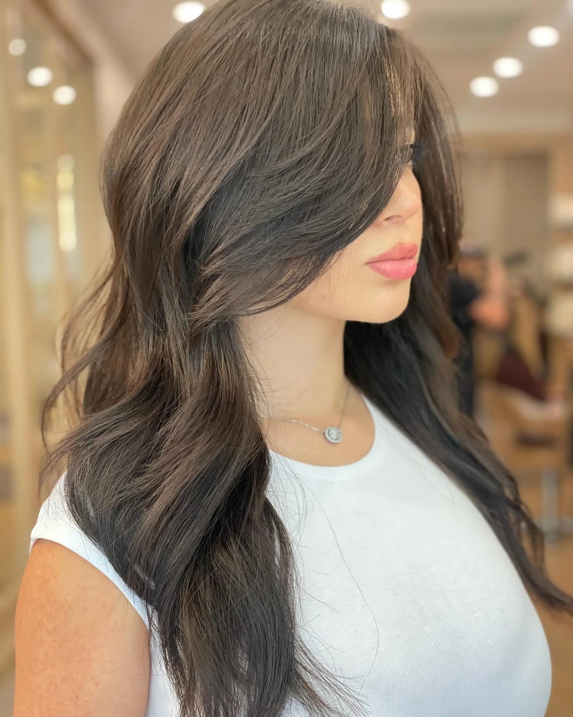 Long layered waves with bronde color and curtain bangs. 1