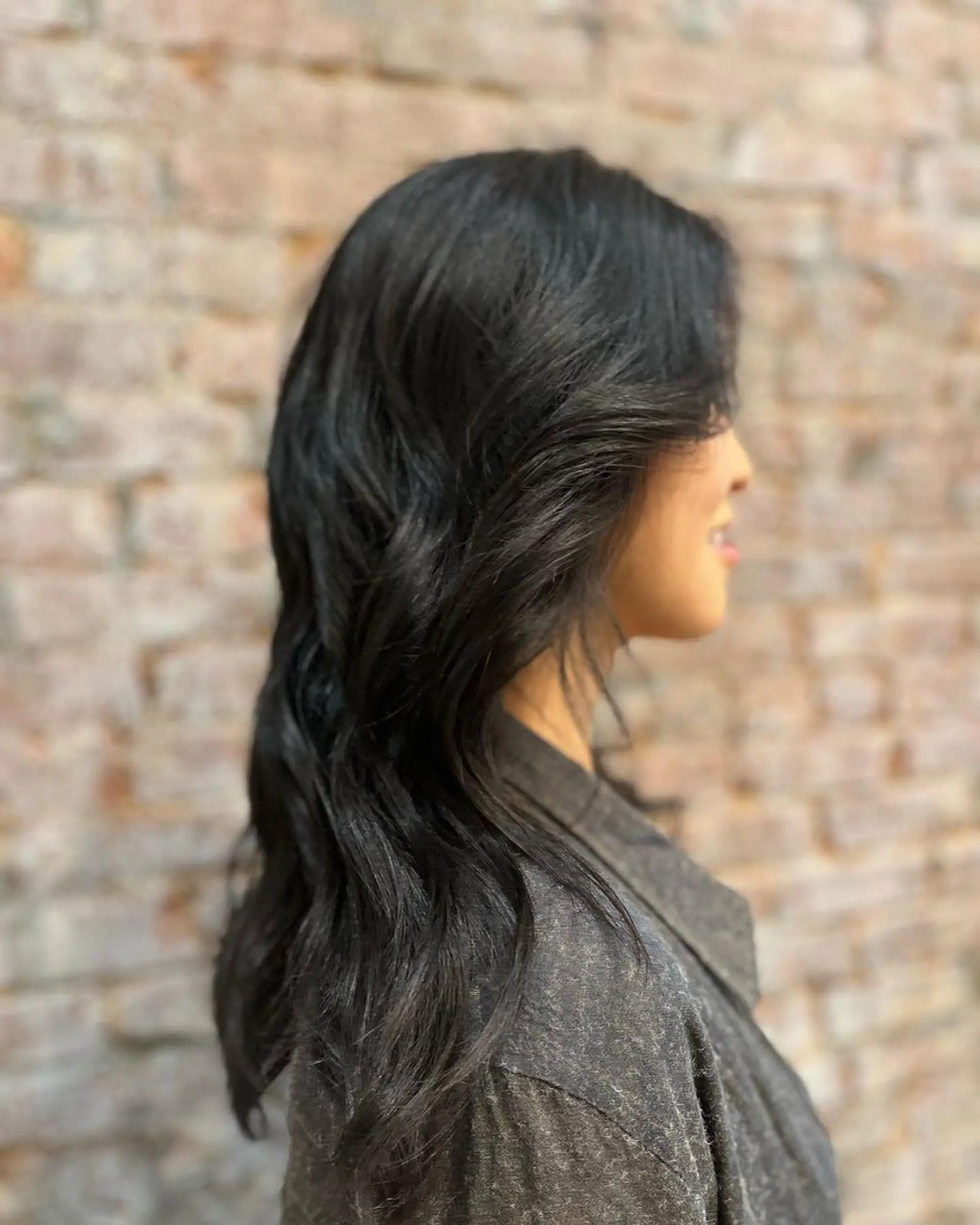 Long, black, wavy hair with a side part, featuring soft, loose waves and a glossy finish. 1