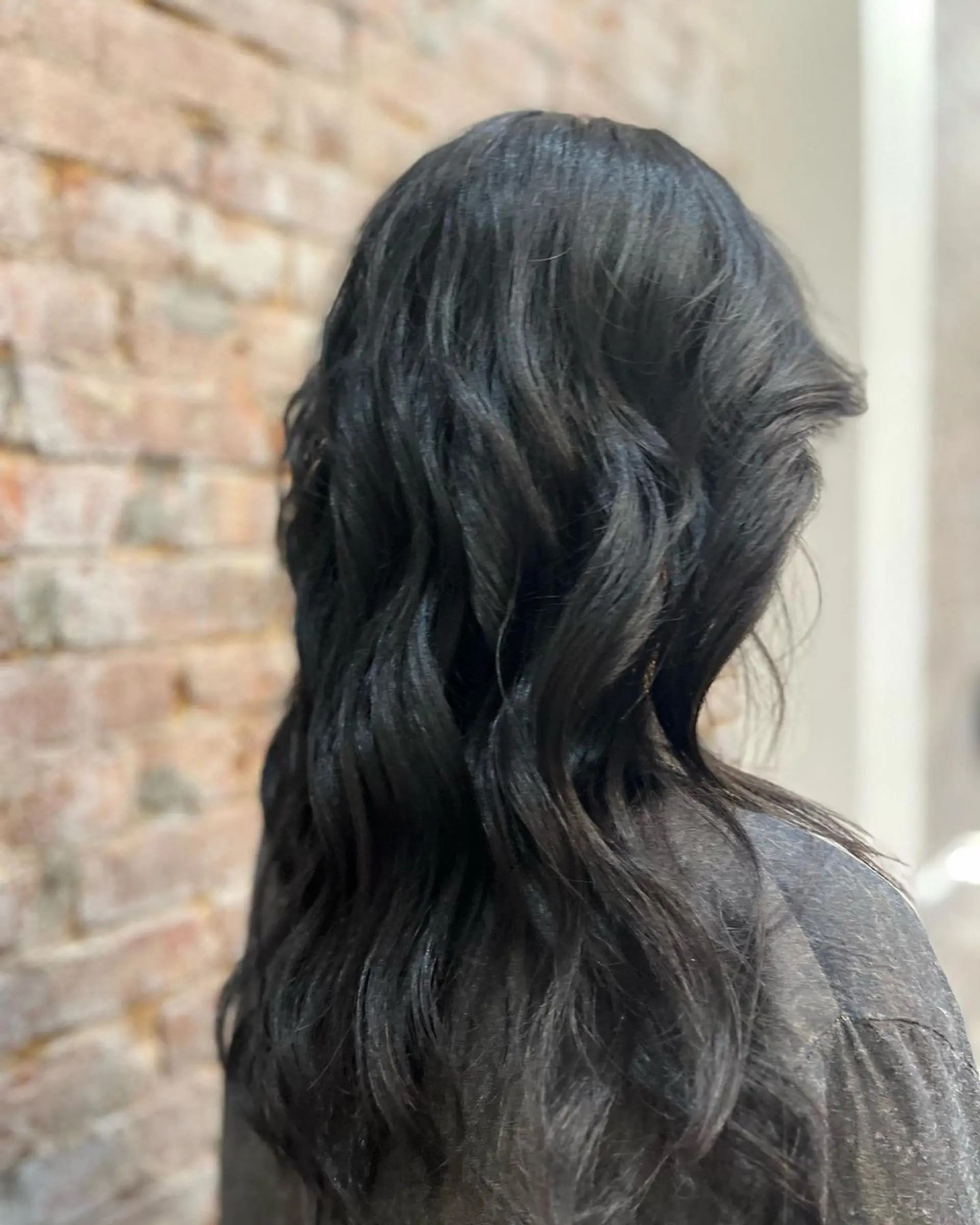 Long, black, wavy hair with a side part, featuring soft, loose waves and a glossy finish. 3