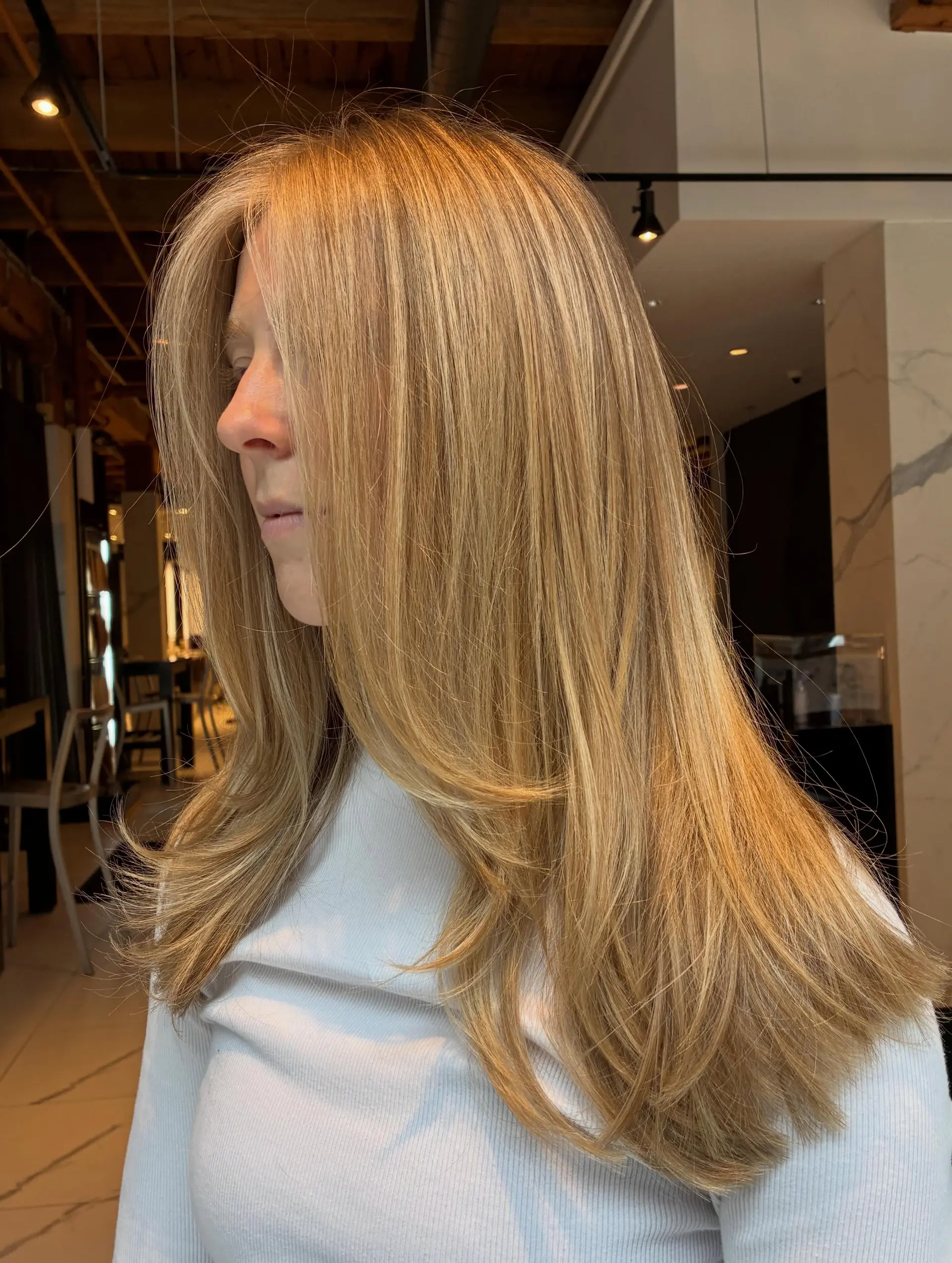 Long golden blonde hair featuring seamless full highlights, face-framing layers, and smooth curved ends. 1