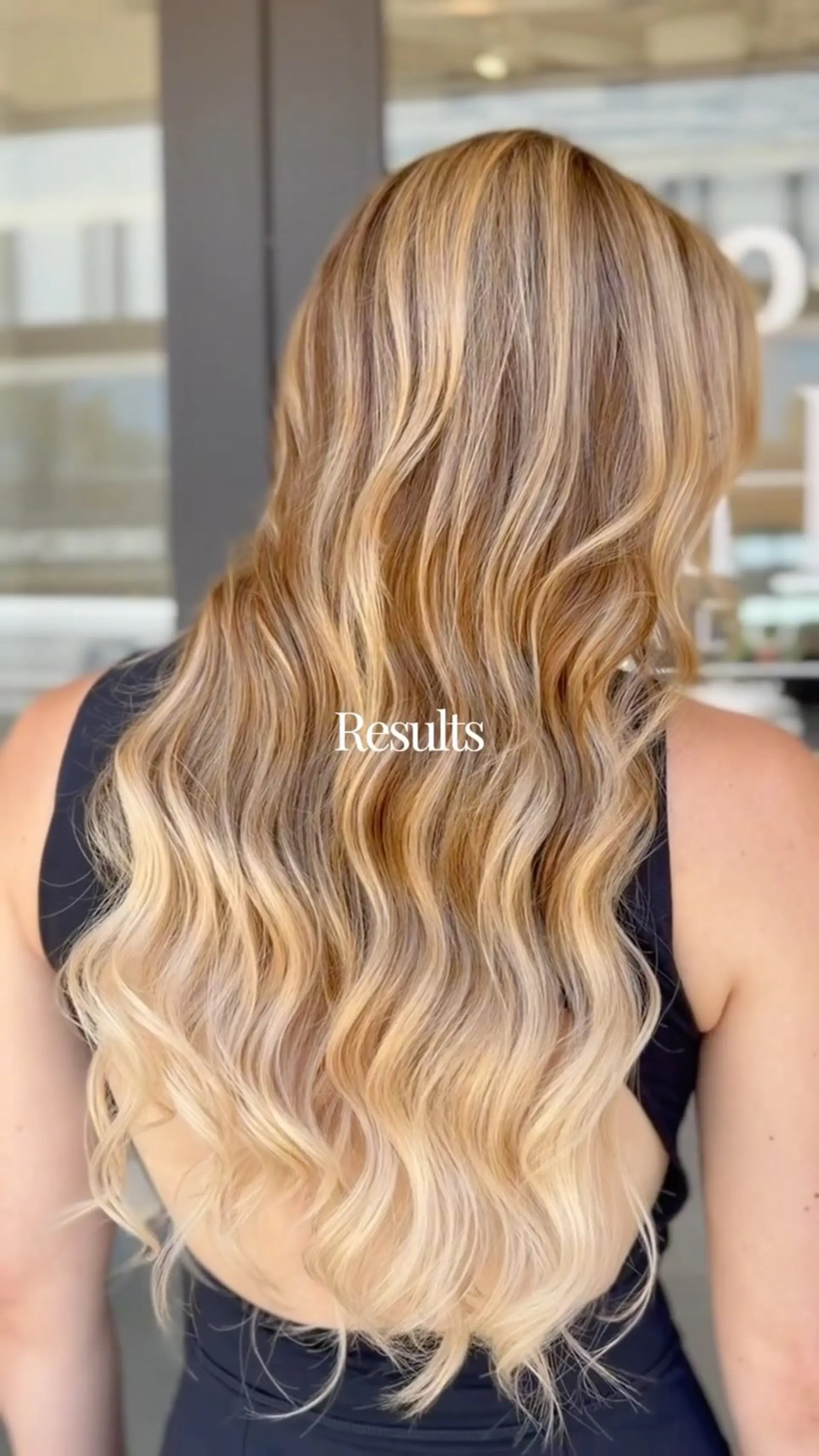 Long, multi-tonal golden blonde hair styled in soft, cascading waves with a smooth, glossy finish. 1