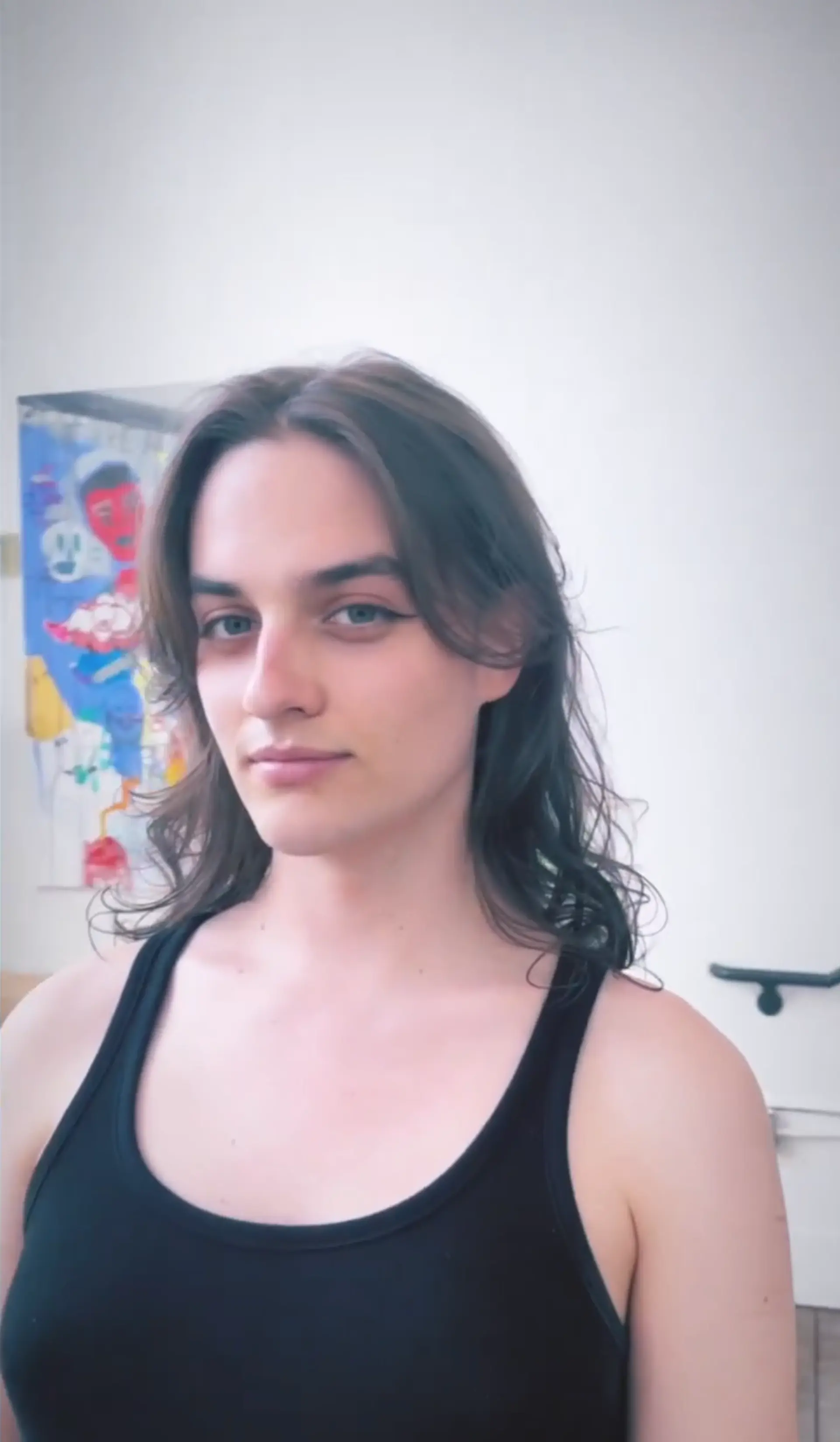 Medium-length, wavy dark brown hair with a middle part and a subtle layered cut. 1