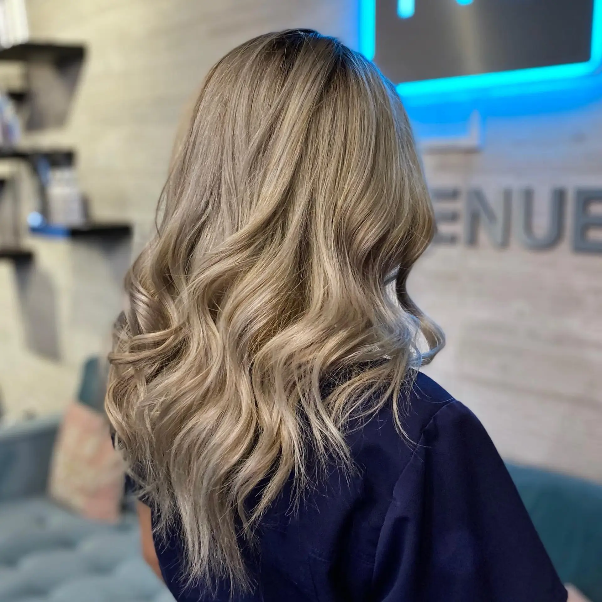 Long vanilla blonde hair styled into soft, flowing beach waves. 1