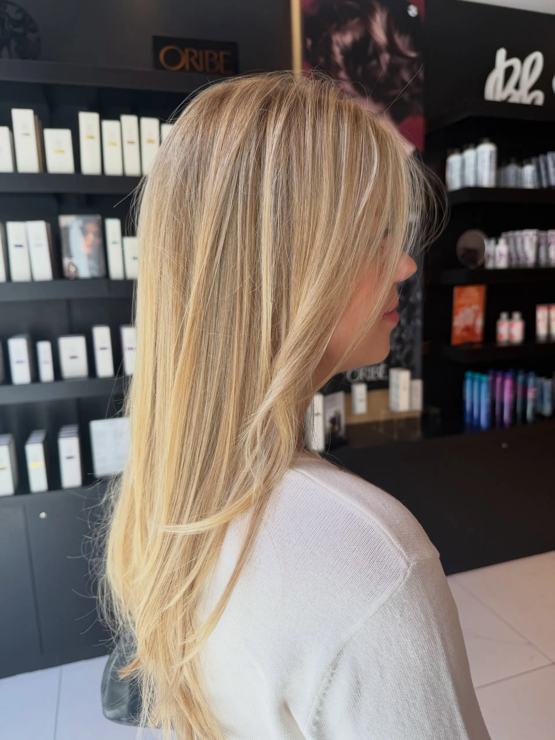 Long dimensional blonde hair styled straight with soft, face-framing layers. 1
