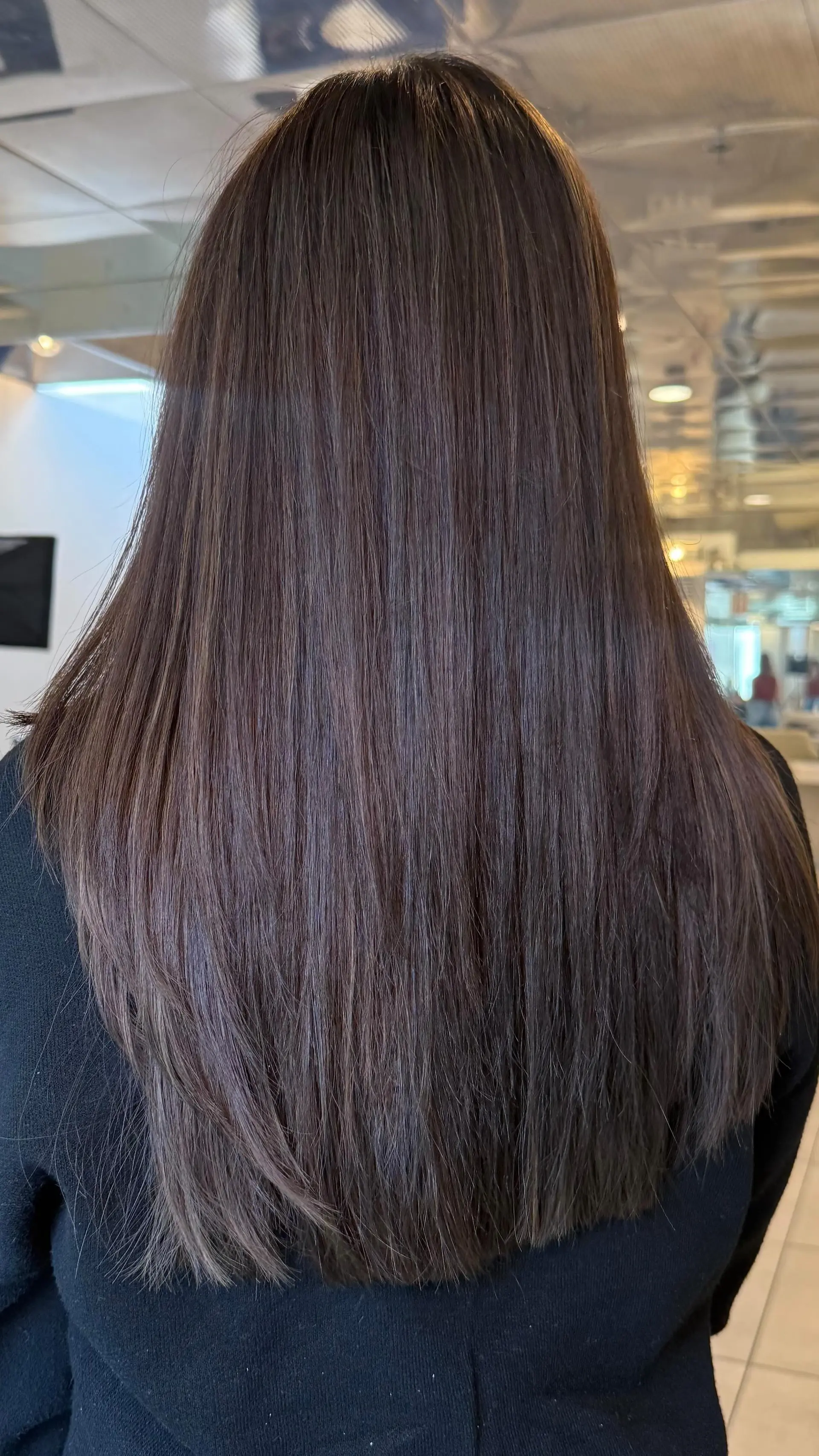 Long, sleek dark brown hair styled straight with a smooth, polished blowout. 1