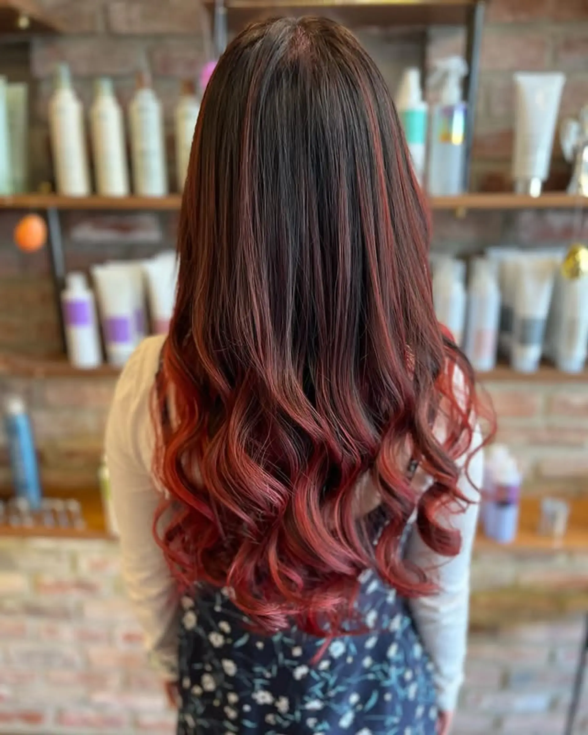 Long, wavy hair with a dark brown to cherry red ombre effect. 1