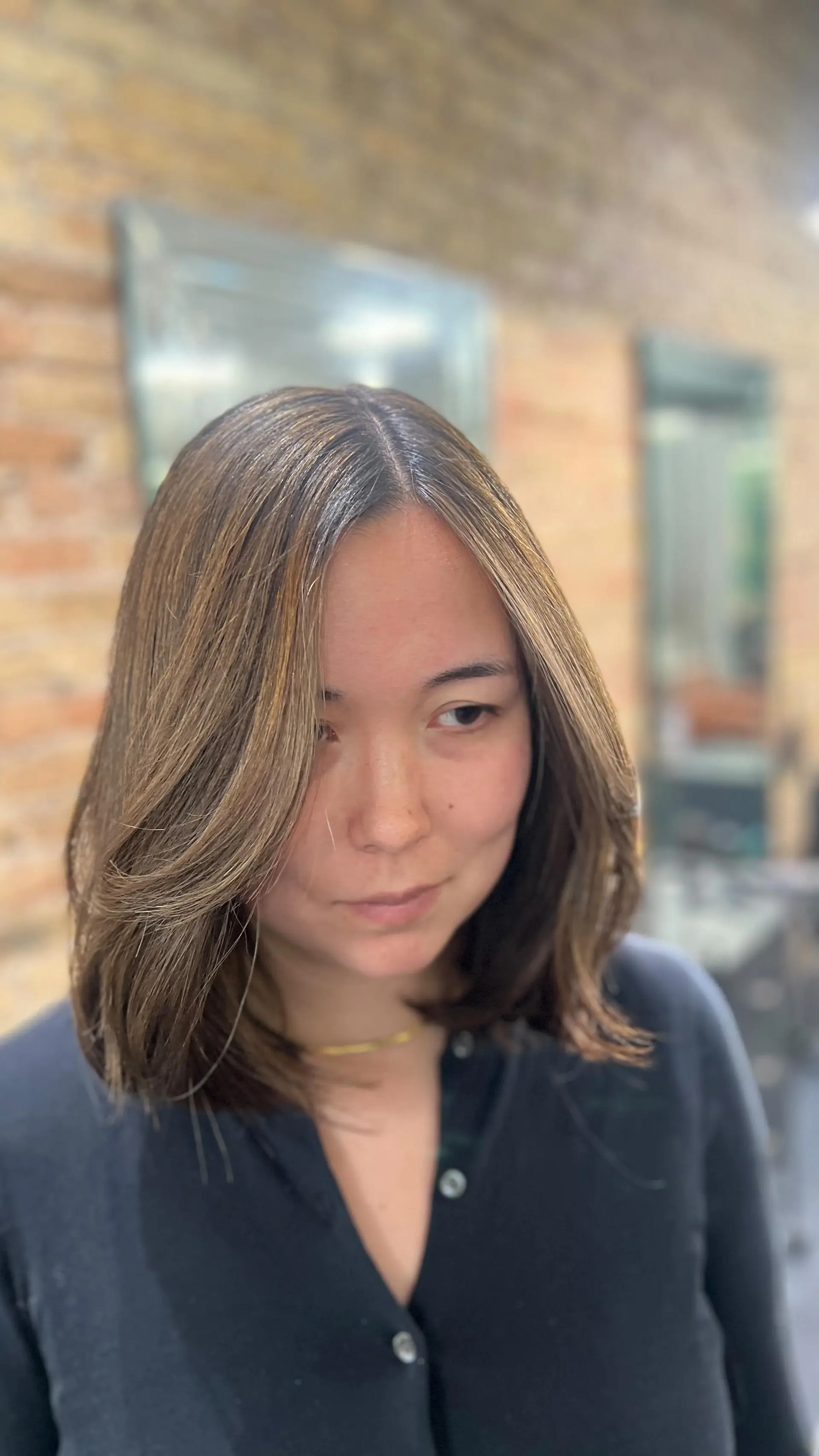 A textured shoulder-length bob cut with soft, layered face-framing fringe and fine caramel highlights. 1