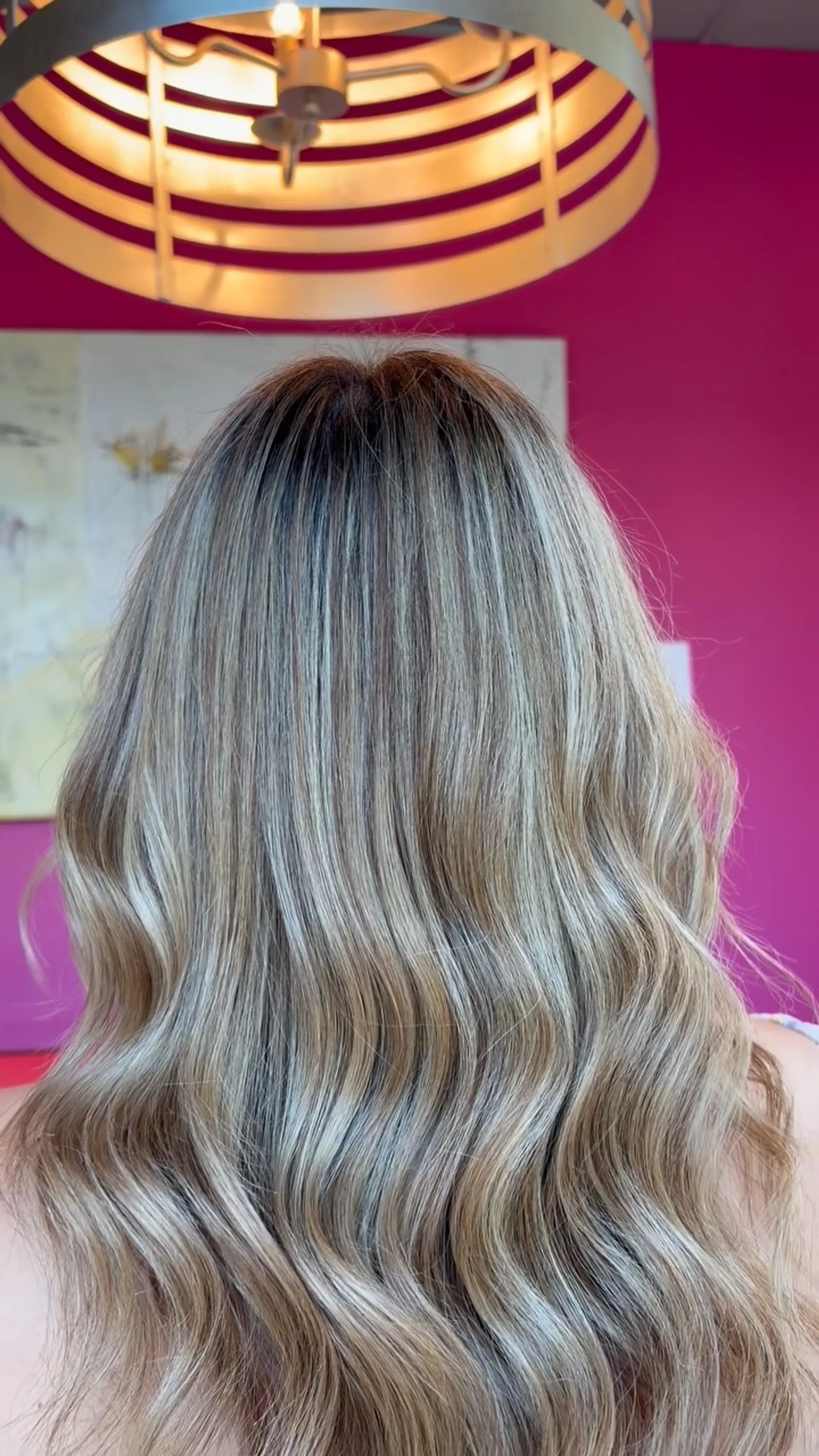 Cool-toned blonde highlights seamlessly blended over a brunette base and finished with soft, flowing waves. 1