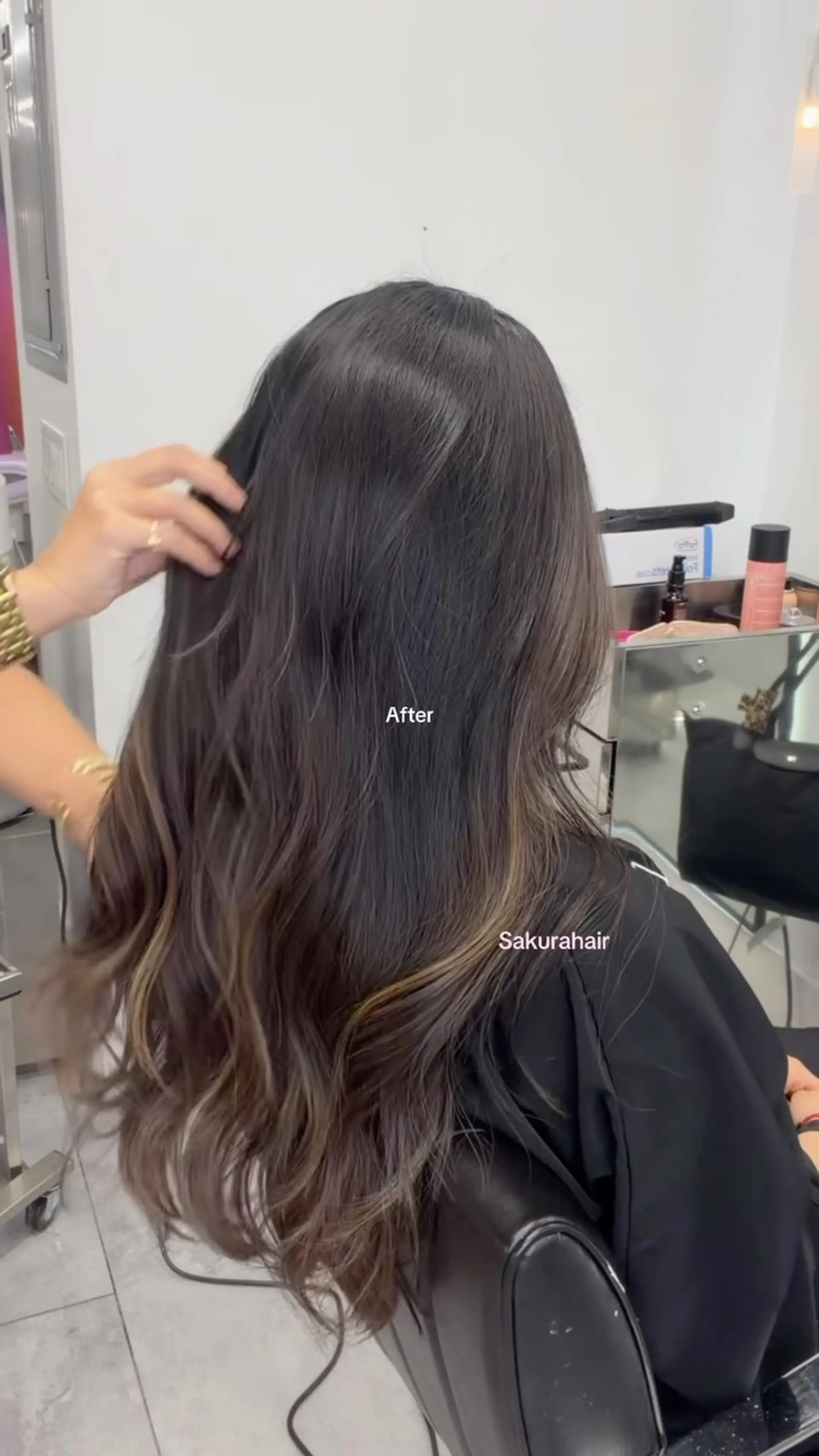 Long dark brown hair styled with subtle lighter brown balayage highlights and soft loose waves. 1