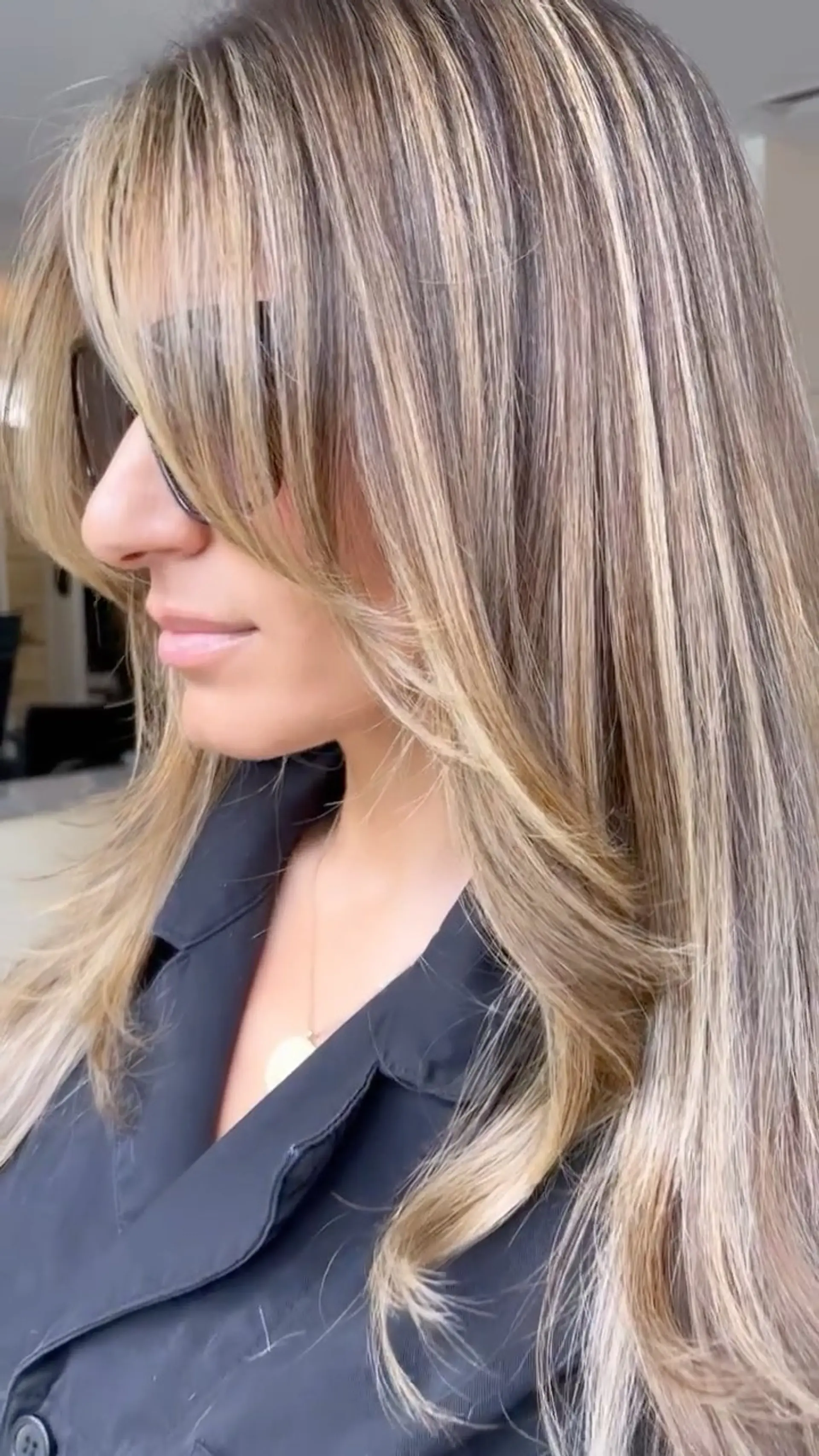 Long hair with wispy bangs and face-framing layers featuring dimensional ash and beige blonde highlights. 1