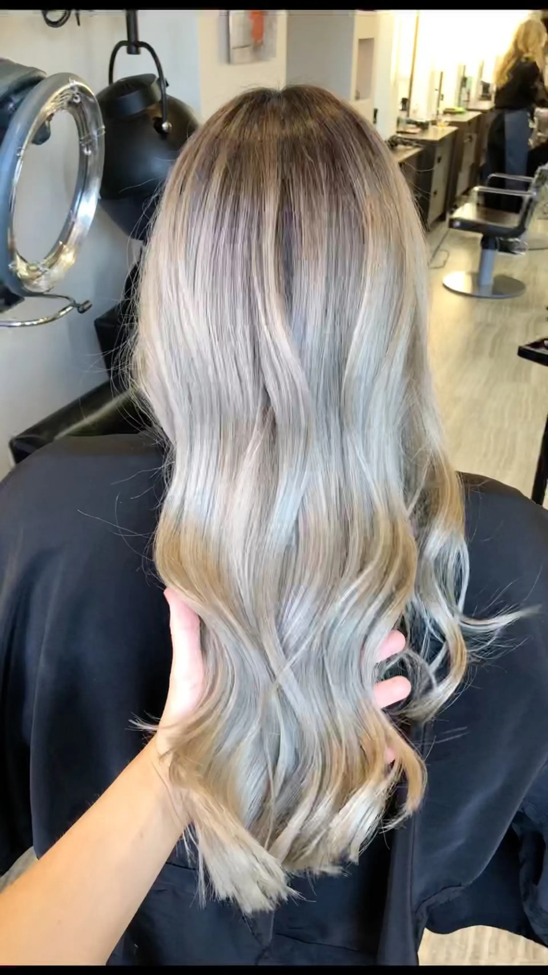 Long ash blonde hair featuring a blended shadow root and styled in loose, dimensional waves. 1