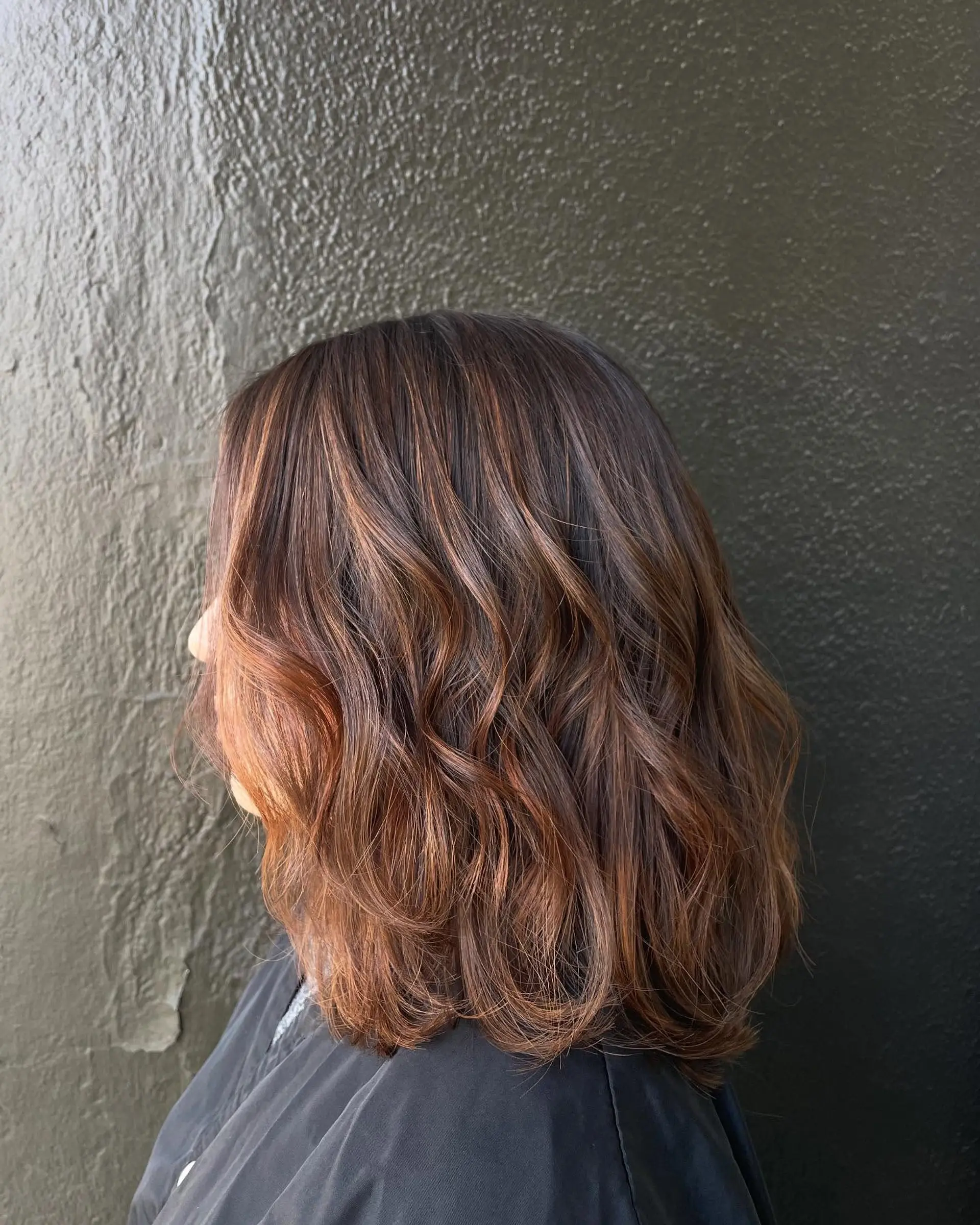 A medium-length wavy lob with bronzed balayage highlights. 1