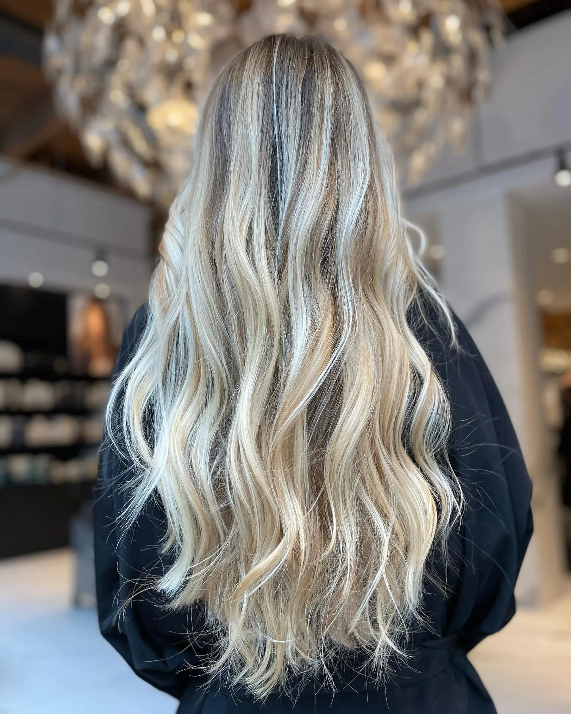 Extra-long hair styled with bright blonde dimensional highlights and soft, loose waves. 1