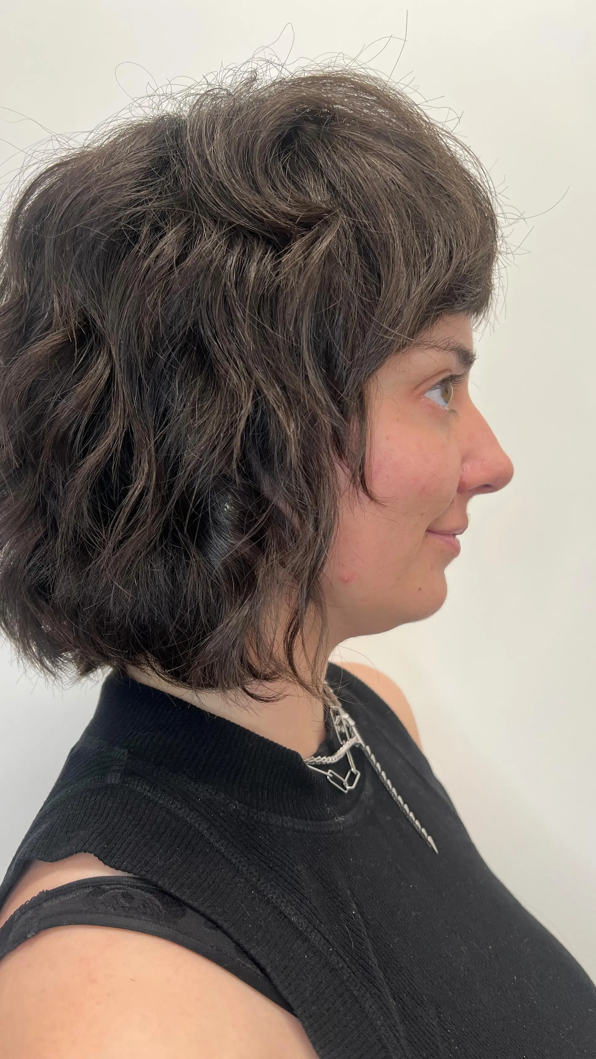 A textured short wavy bob haircut styled with tousled waves and soft bangs. Current Haircut option: $140 before tax. Haircut and included finish only; color is not included. 1