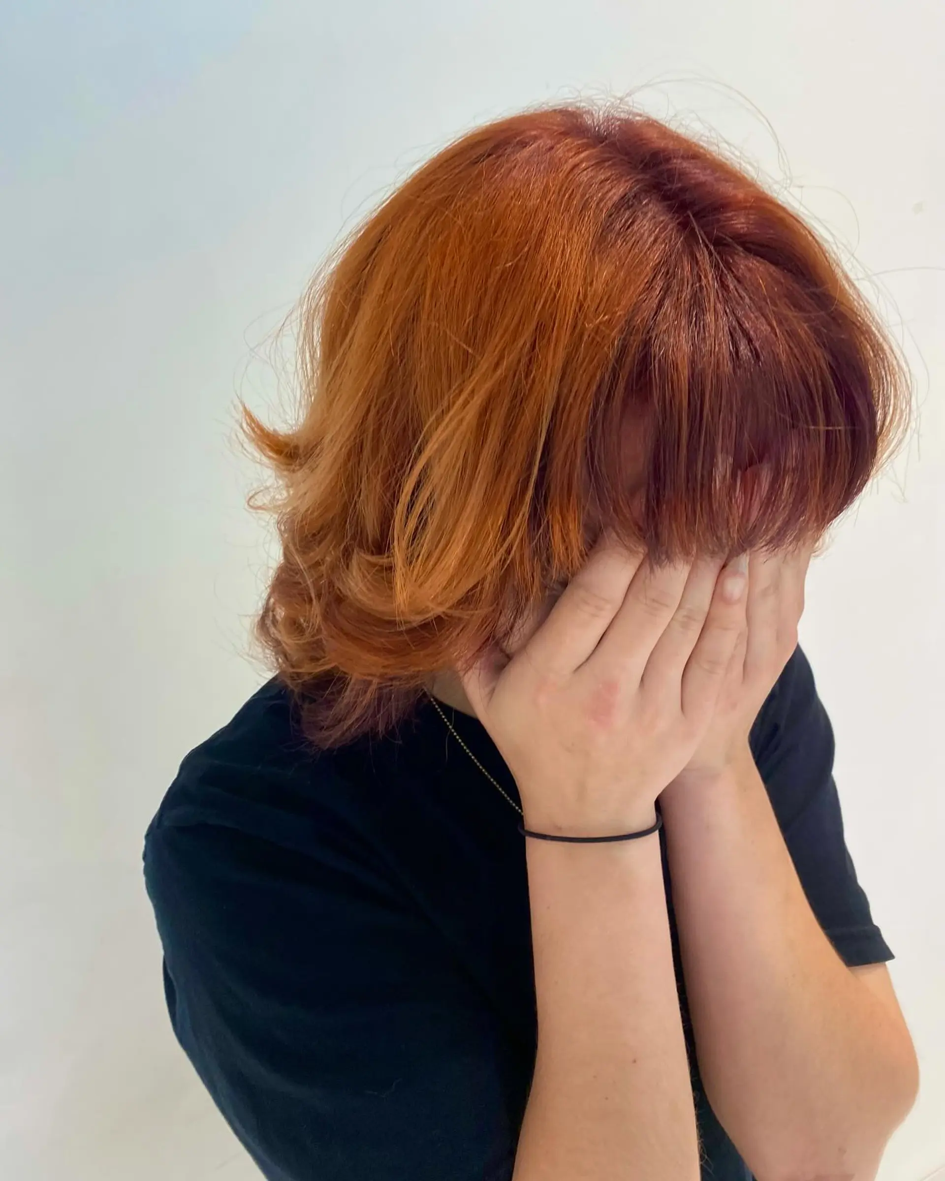 A textured short copper shag featuring flipped, layered ends and full straight-across bangs. 1