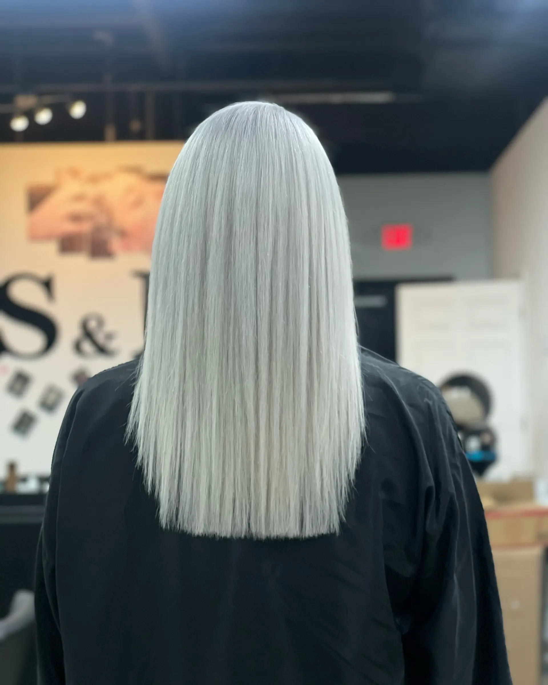 A long, sleek, straight lob hairstyle dyed platinum blonde or silver. 1