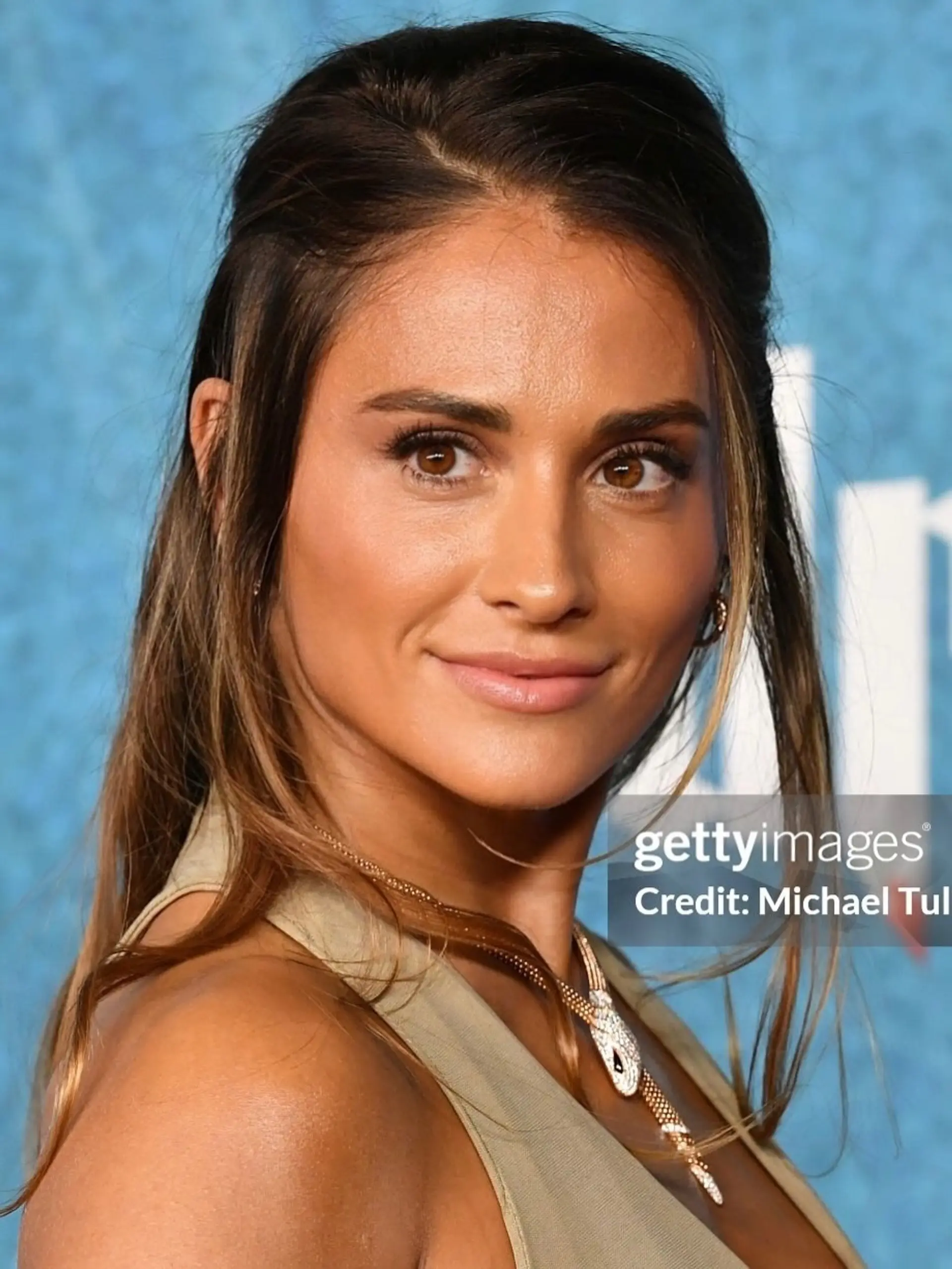 A sleek and glamorous red carpet hairstyle with the top sections pulled softly back, featuring wispy, face-framing strands and dimensional caramel highlights. 1