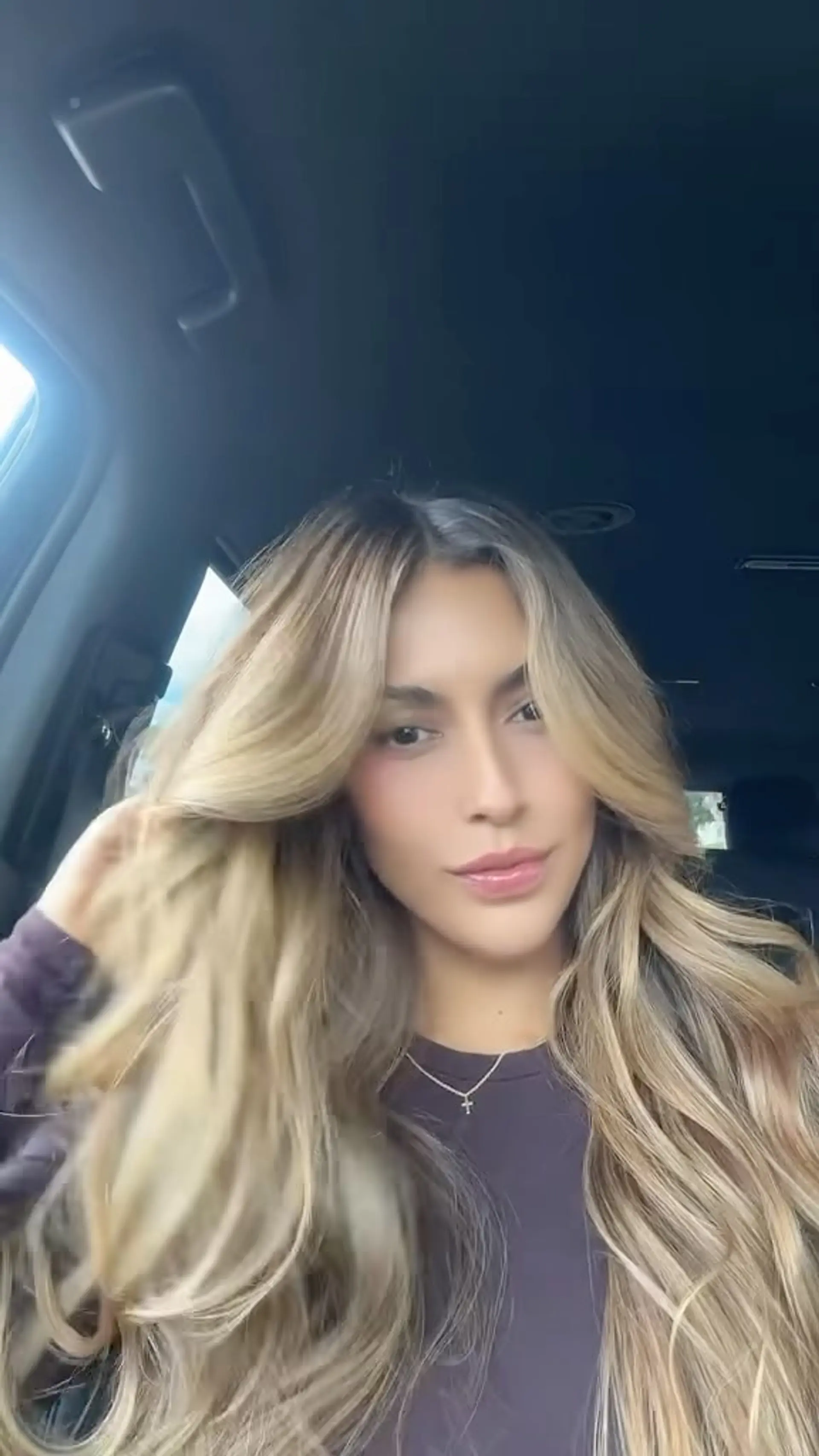 Long beige blonde balayage styled with voluminous blowout waves and face-framing curtain bangs. 1
