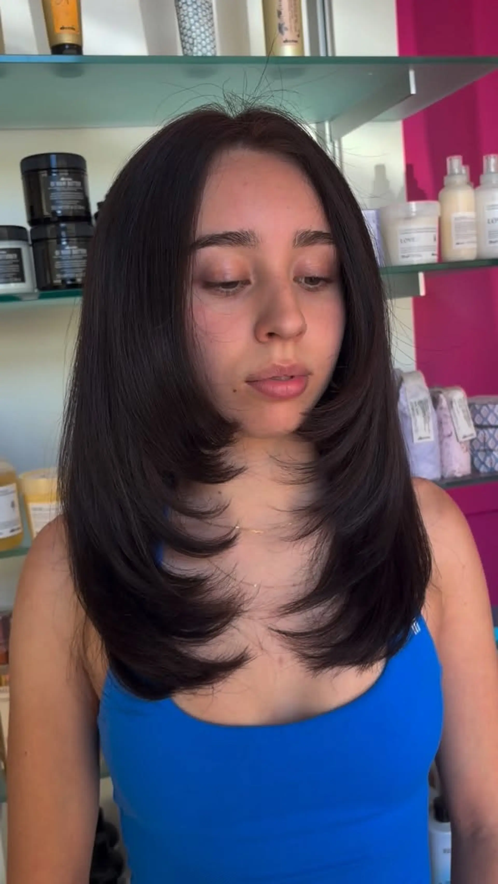 Medium-length dark brown hair with distinct face-framing layers styled curving inwards. 1