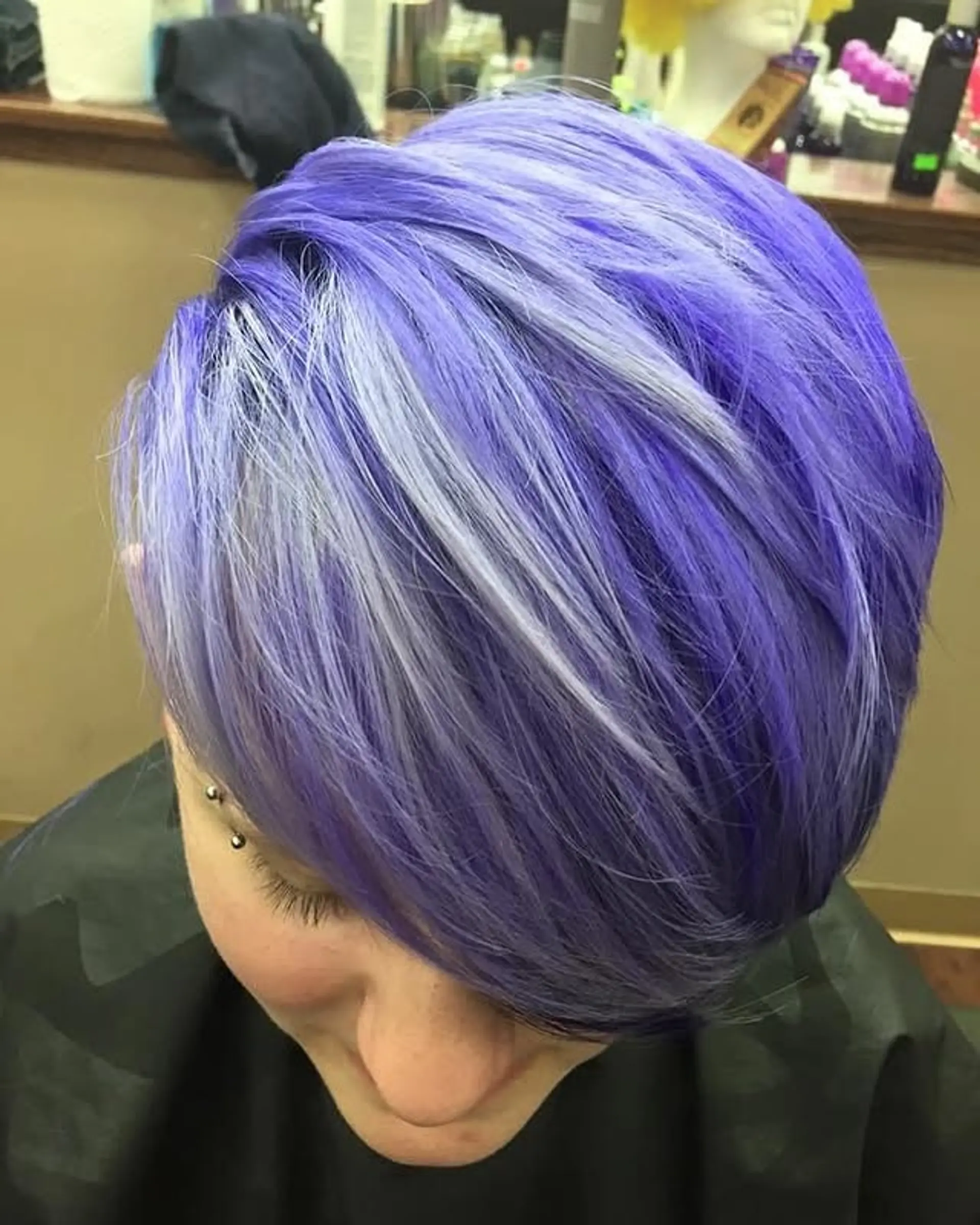A short, layered pixie cut with vibrant lavender base and striking silver highlights. 1