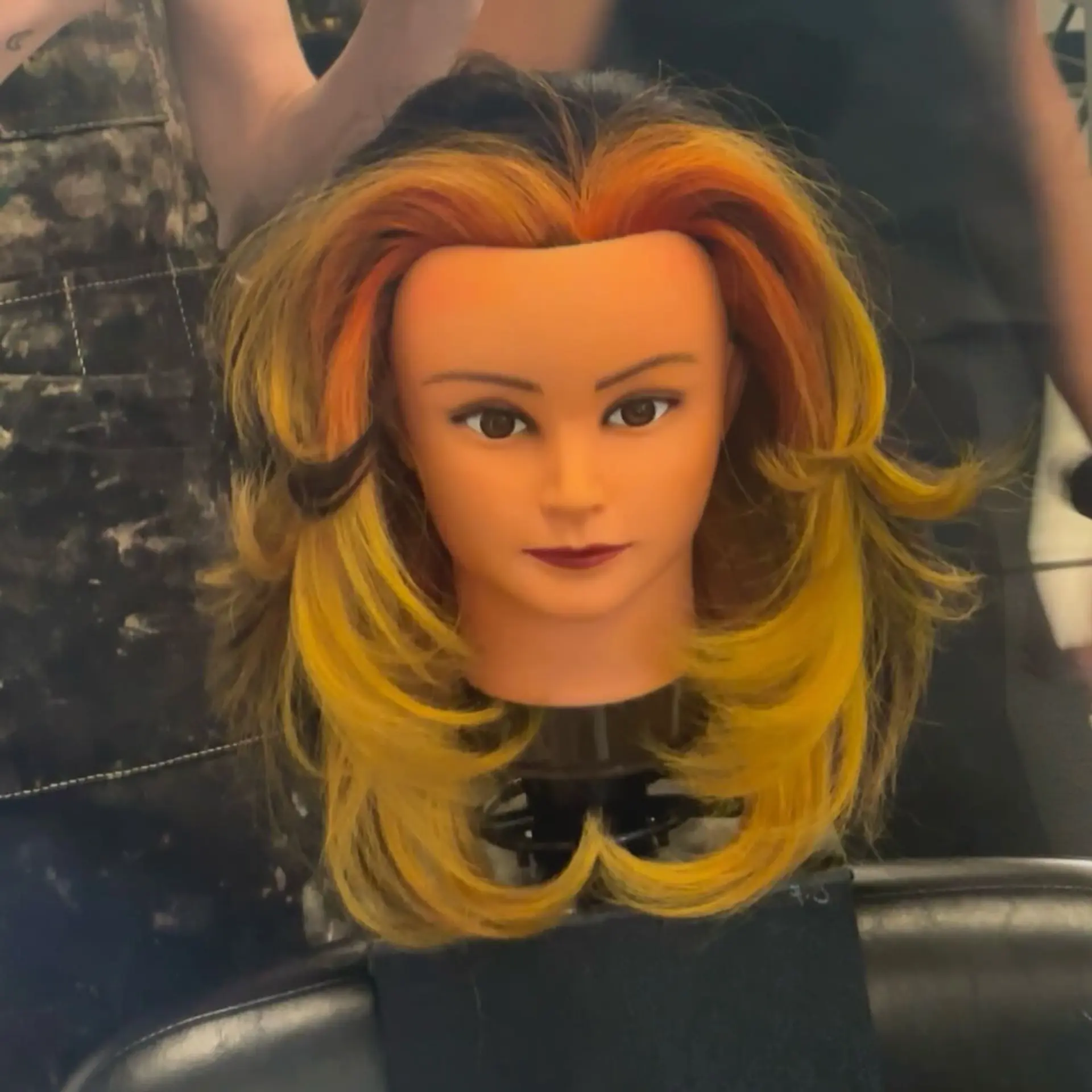 A mid-length layered cut featuring feathered, voluminous face-framing layers and a vivid sunset halo color melt transitioning from fiery orange to bright yellow against dark undertones. 1