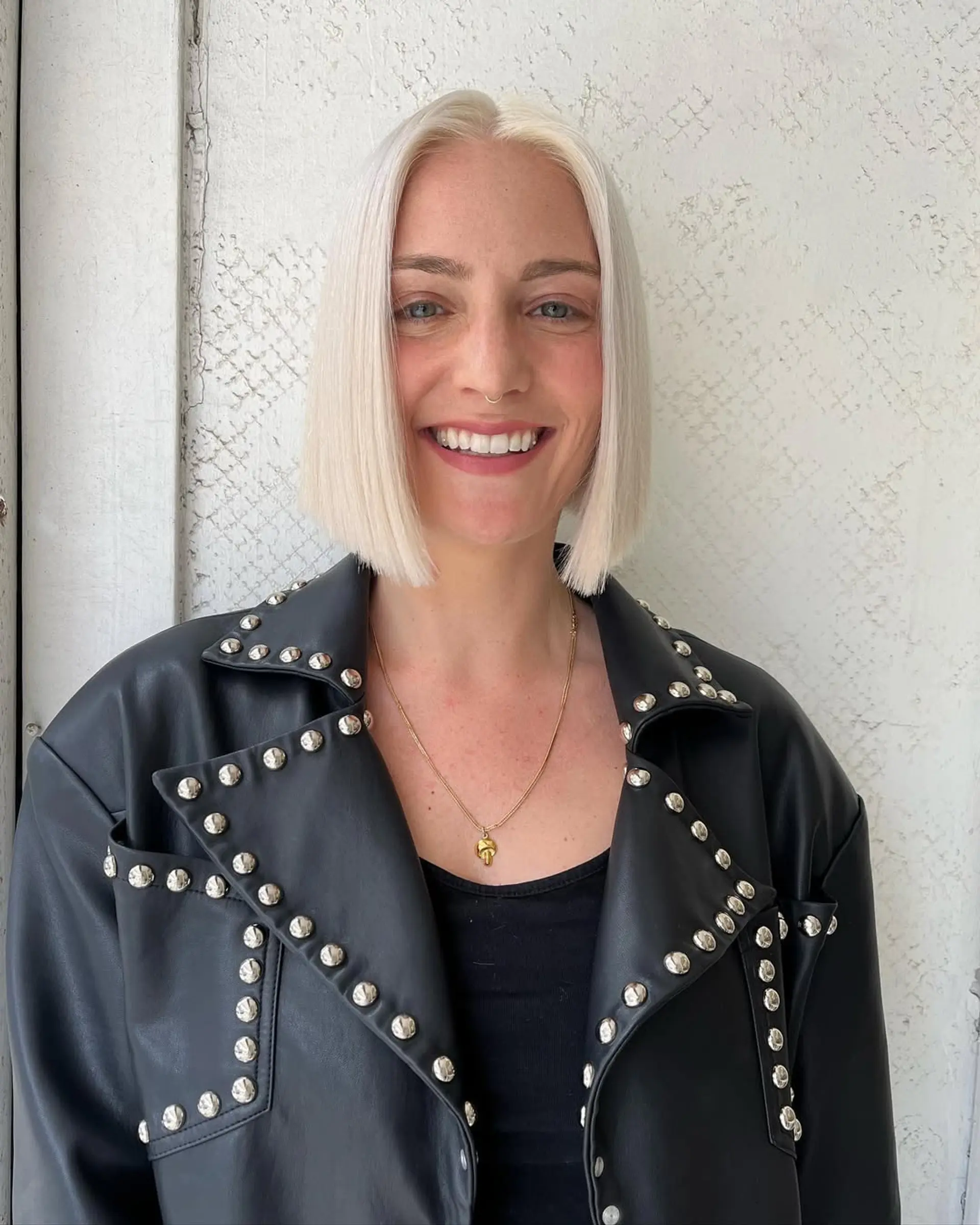 A sleek, blunt cut platinum blonde bob, parted in the center with a smooth, sleek finish. 1