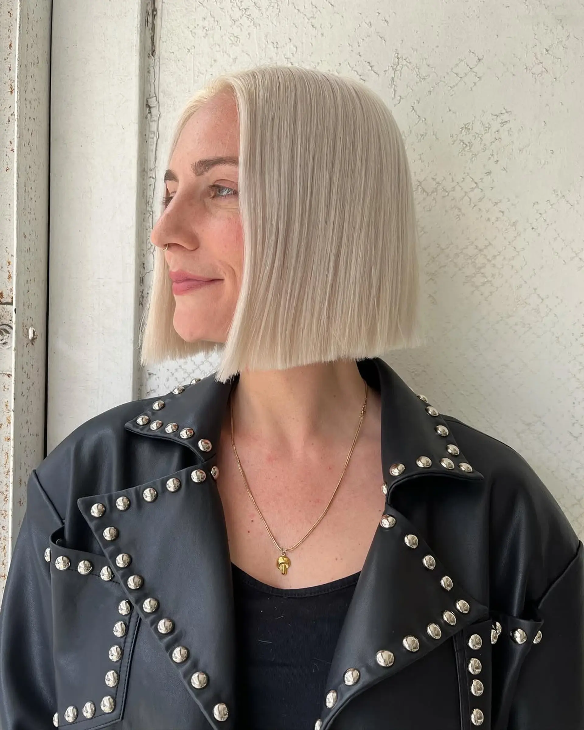 A sleek, blunt cut platinum blonde bob, parted in the center with a smooth, sleek finish. 2