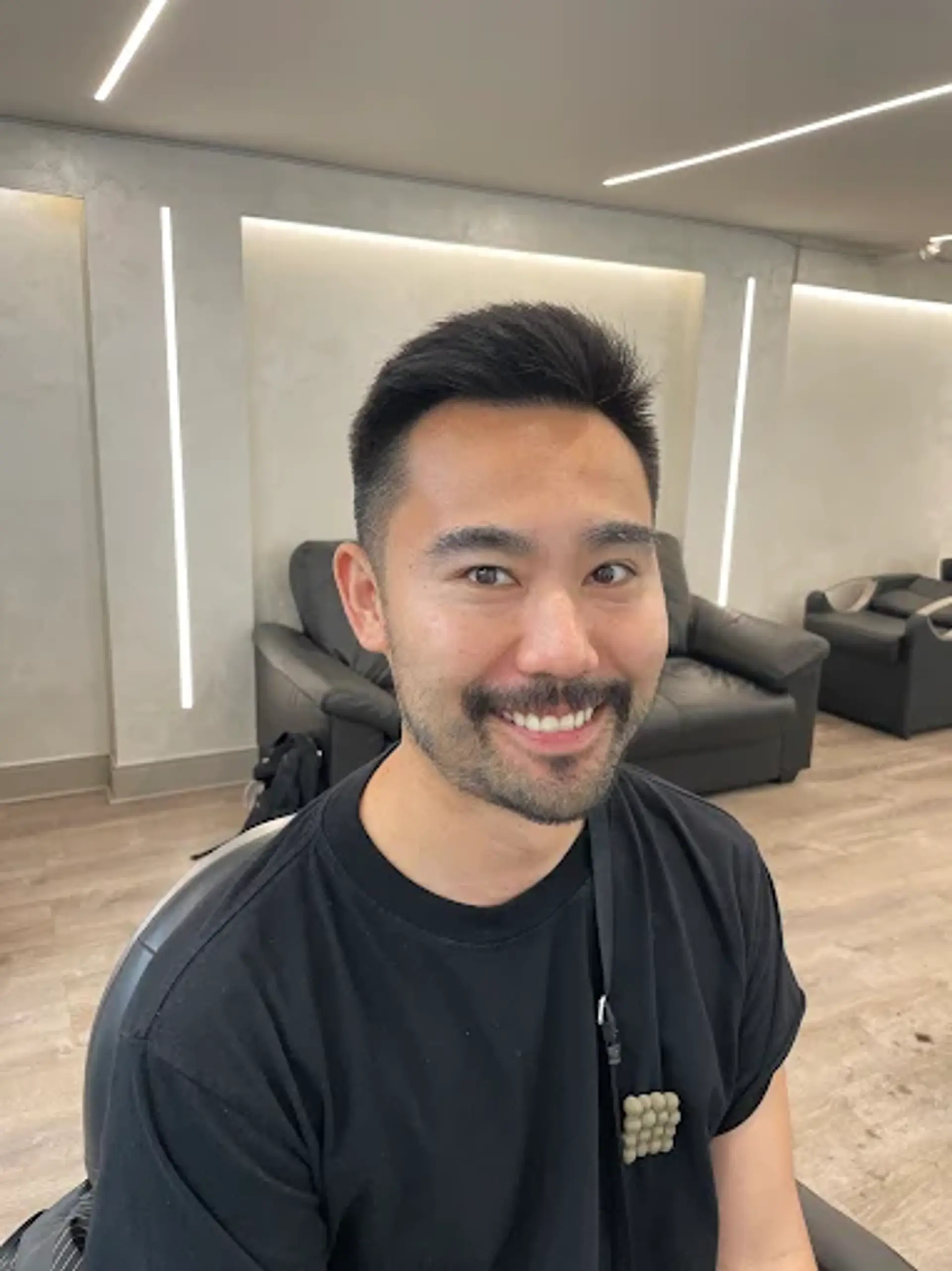 A crisp men's haircut with a short taper fade on the sides and back, and a textured top styled upwards for volume and a contemporary finish. 1