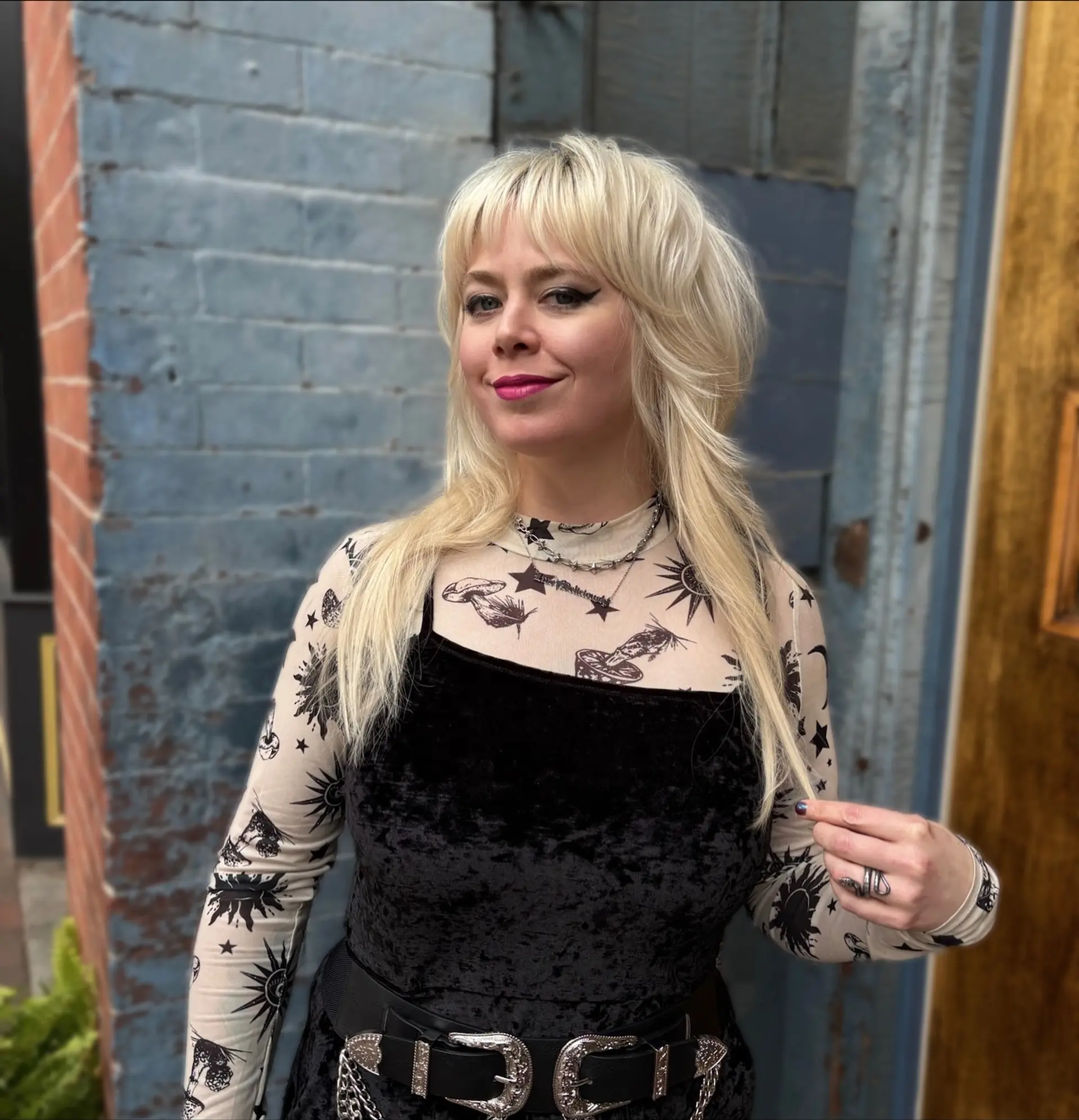 A modern platinum blonde shag mullet featuring feathered, face-framing layers and wispy straight fringe bangs. 1