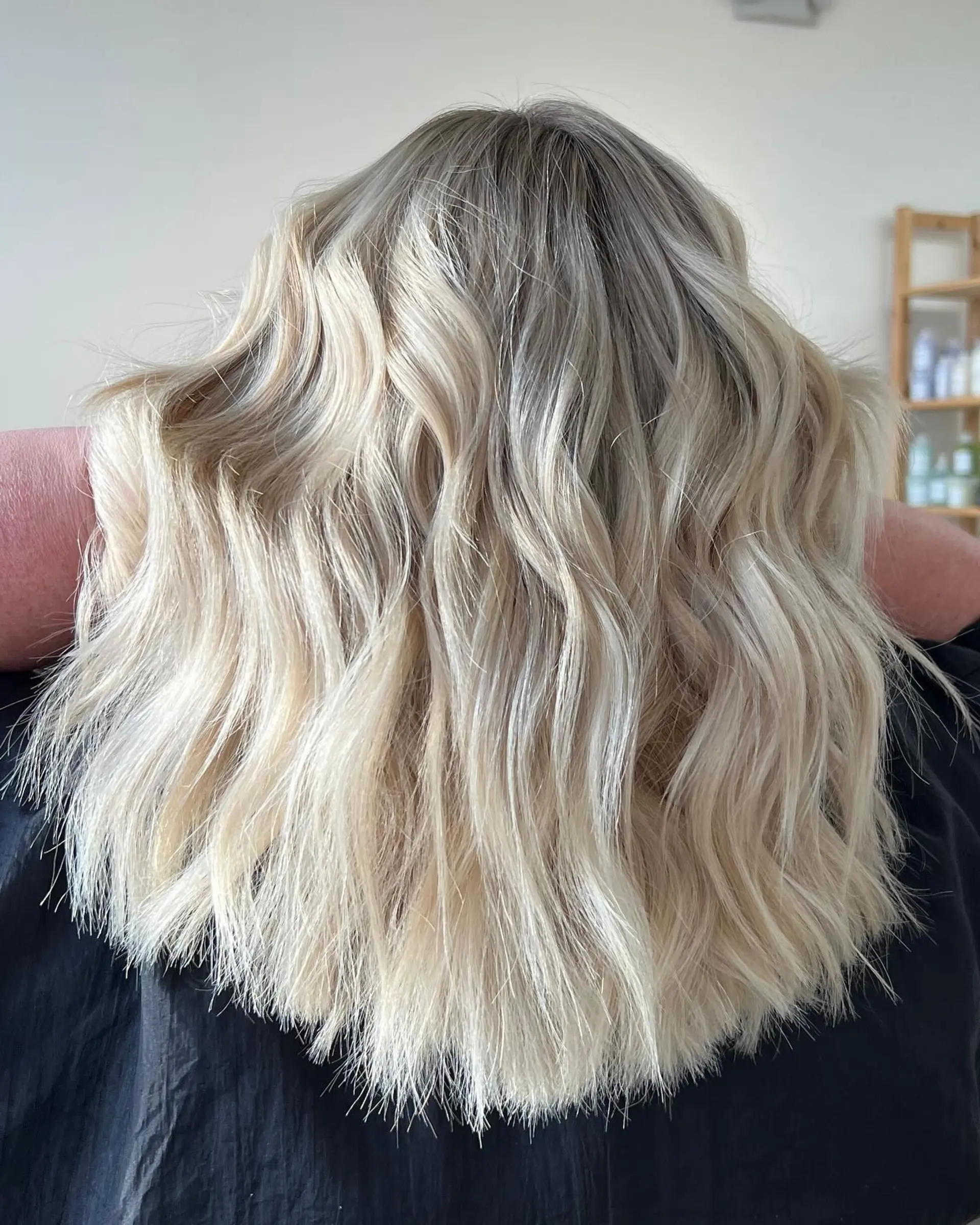 Medium-length bright white blonde hair styled into loose, textured waves. 1