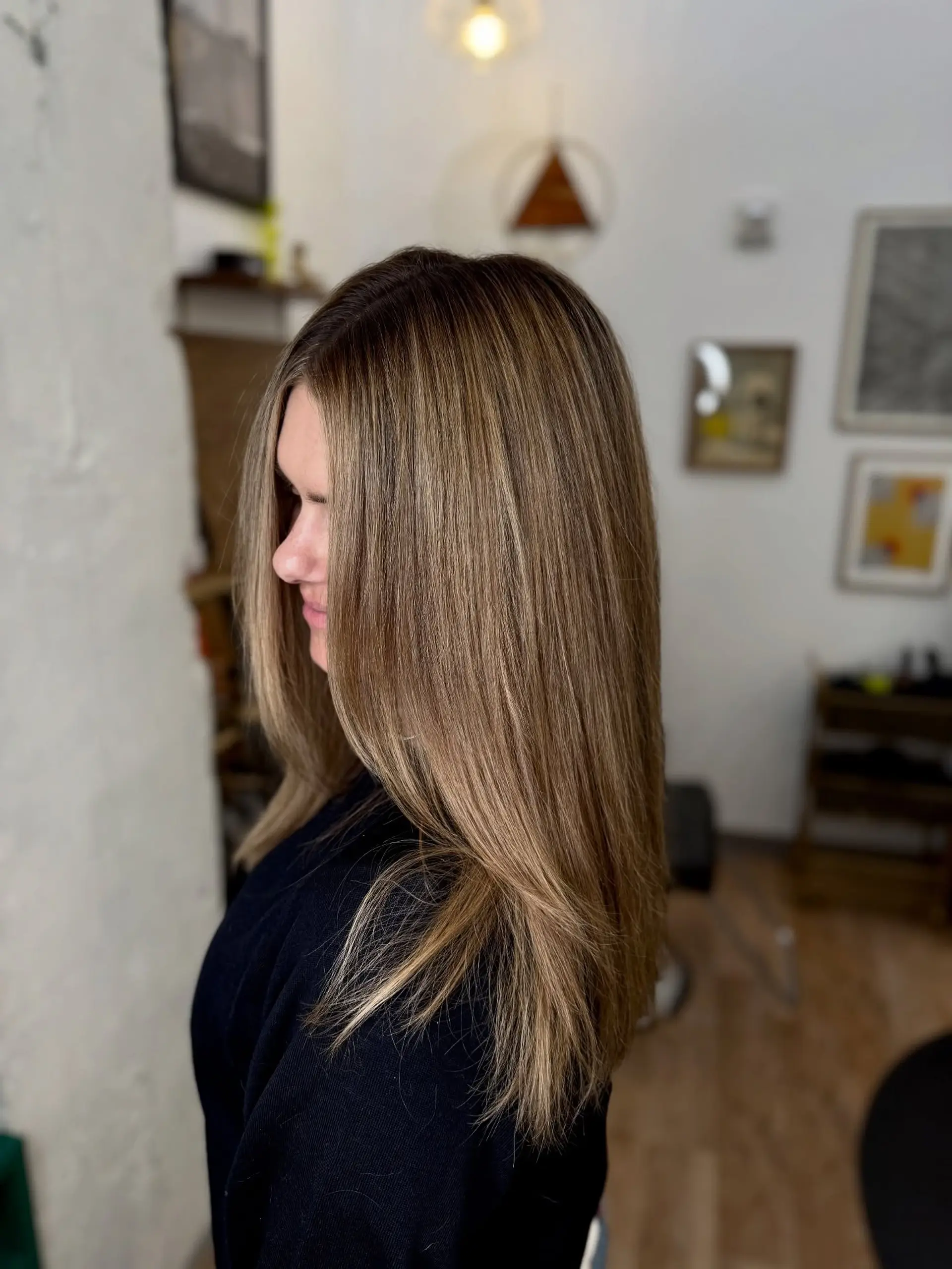 Long straight bronde hair styled smooth with a seamless root shadow and warm caramel blonde dimension. 1