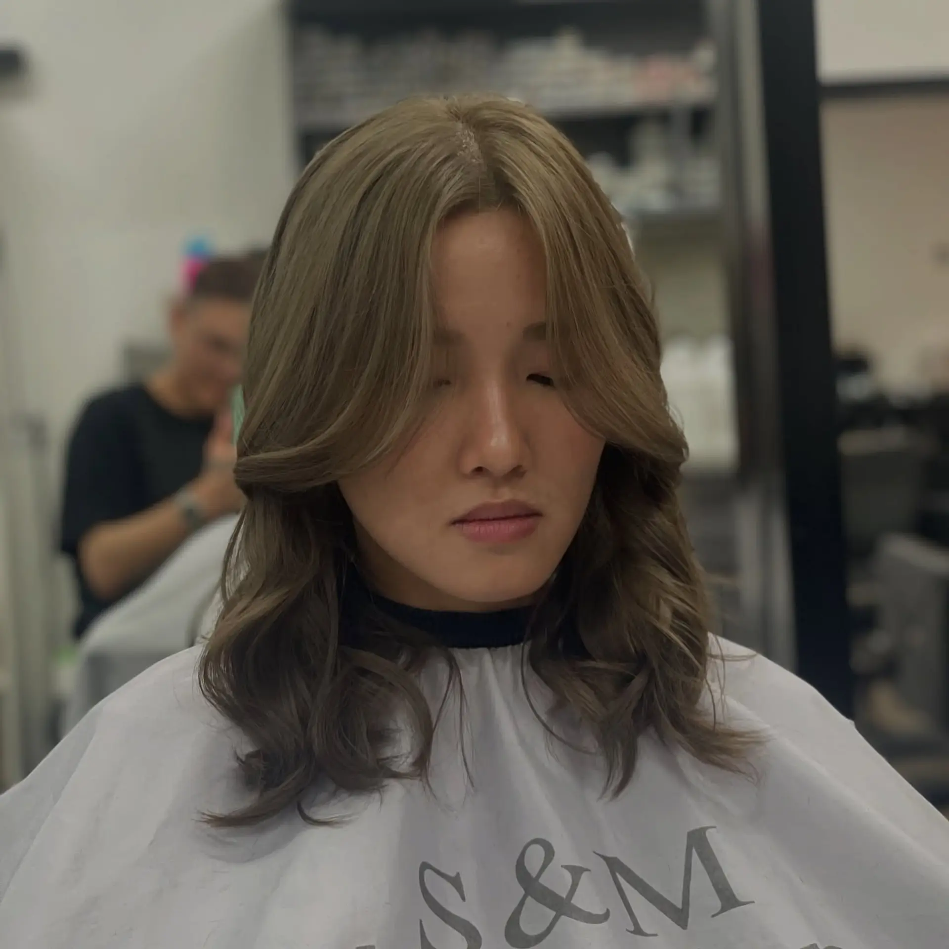 A medium-length wavy hairstyle with face-framing layers and curtain bangs. 1