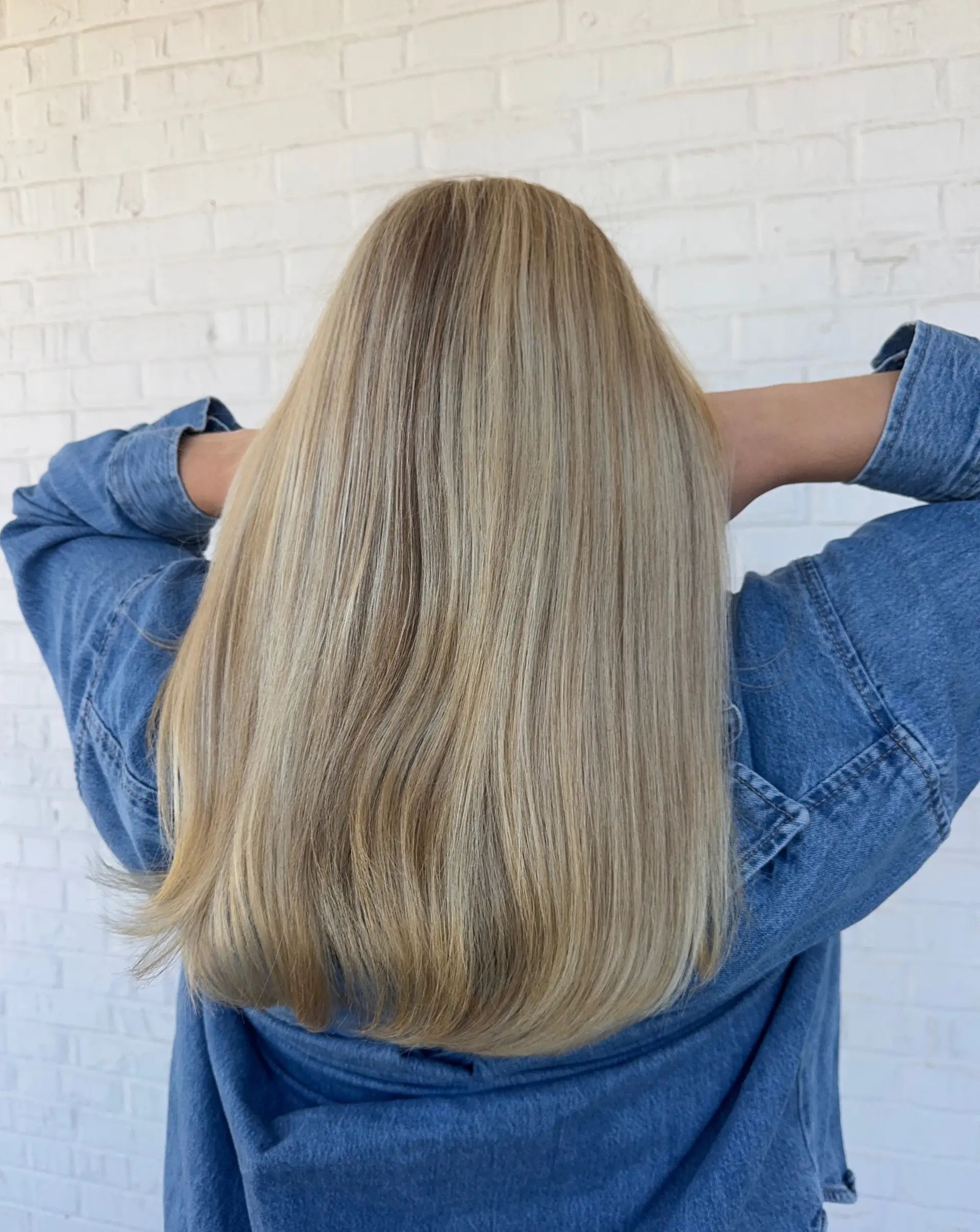 Medium-length straight blonde hair featuring finely blended highlights styled in a sleek blowout. 1