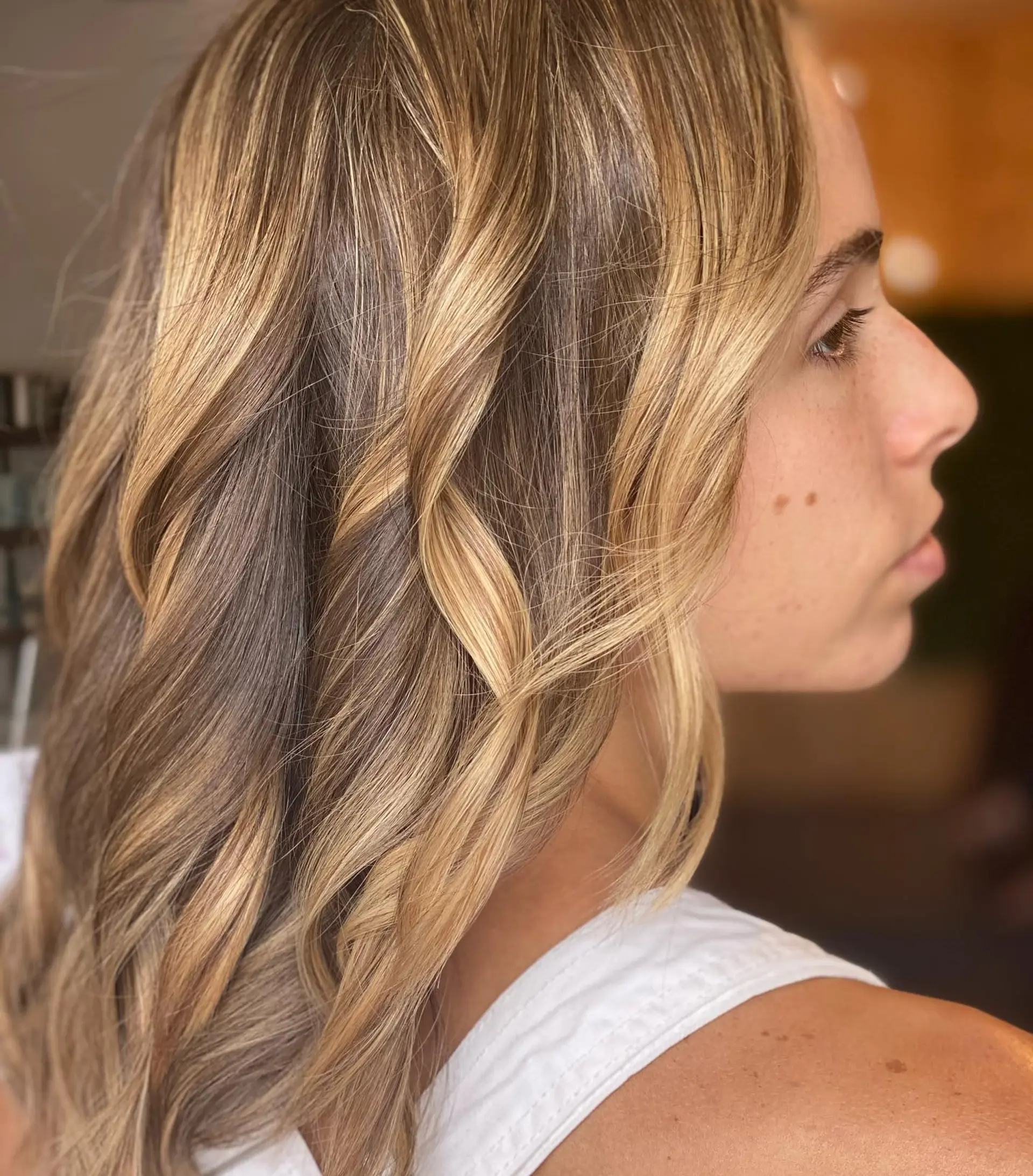 Dimensional golden blonde highlights styled into loose, undone beach waves. 1