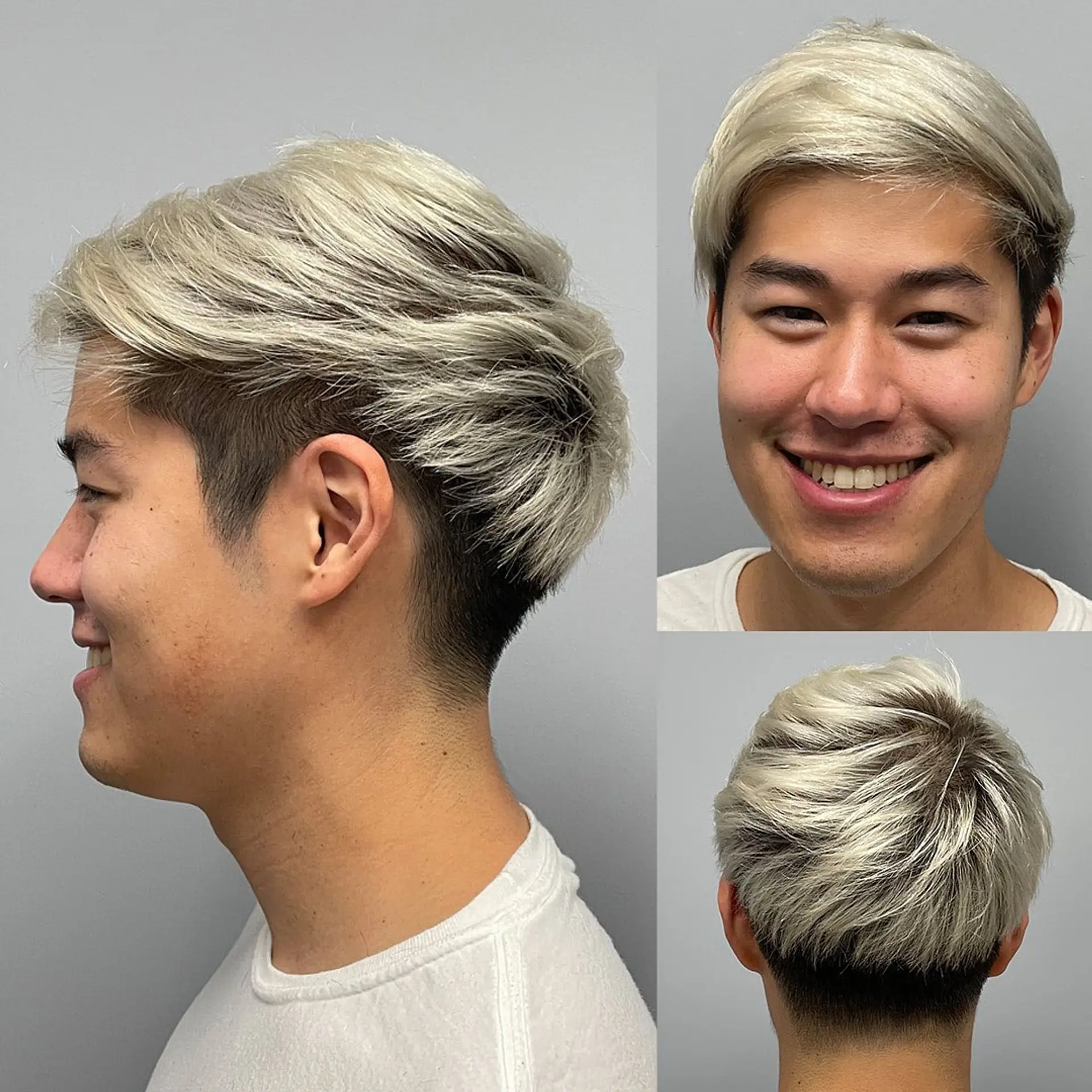 A modern men's haircut featuring closely tapered dark undercut sides paired with a textured platinum blonde layered top styled with soft volume. 1