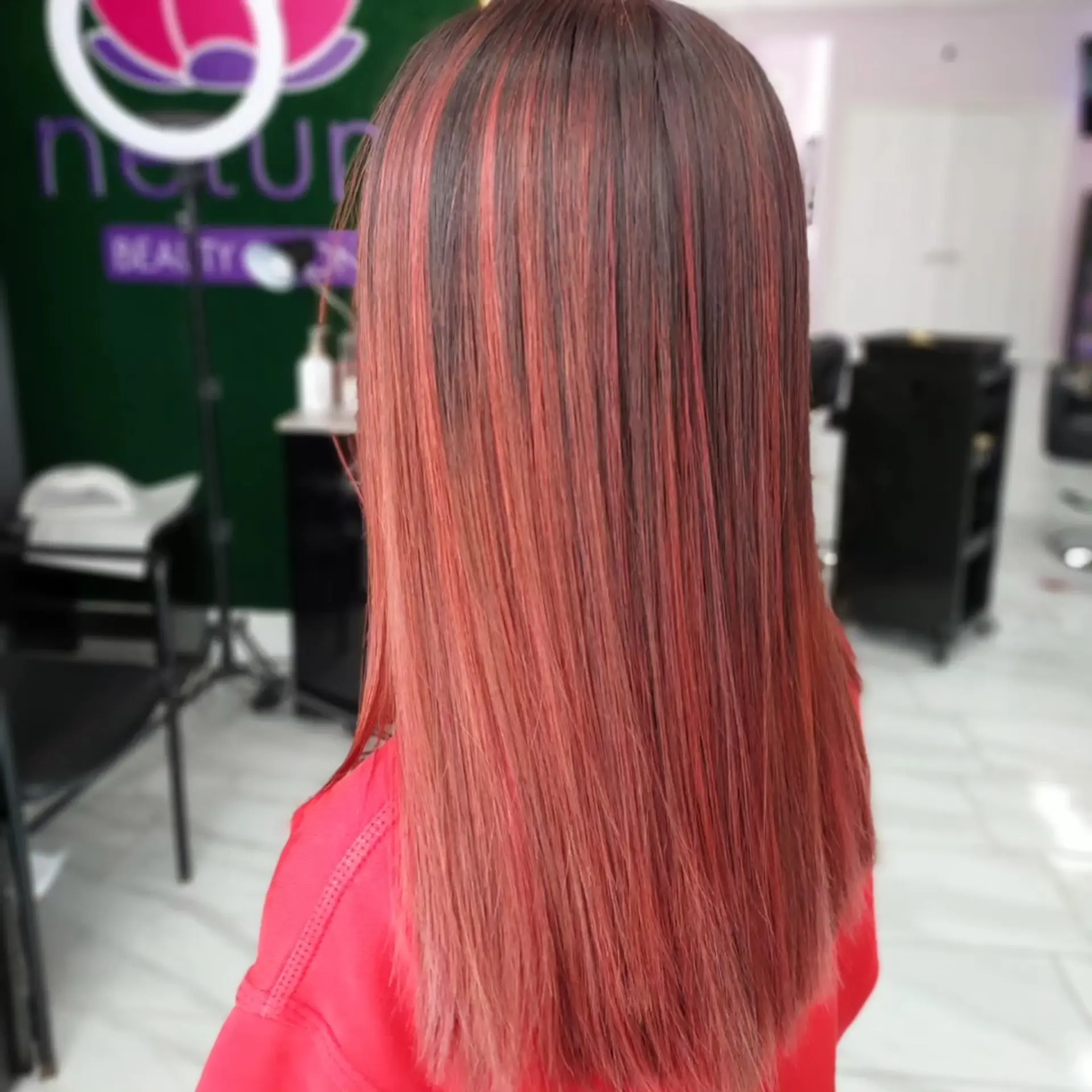 Sleek straight mid-back hair featuring vibrant red streaks and highlights over a dark base. 1