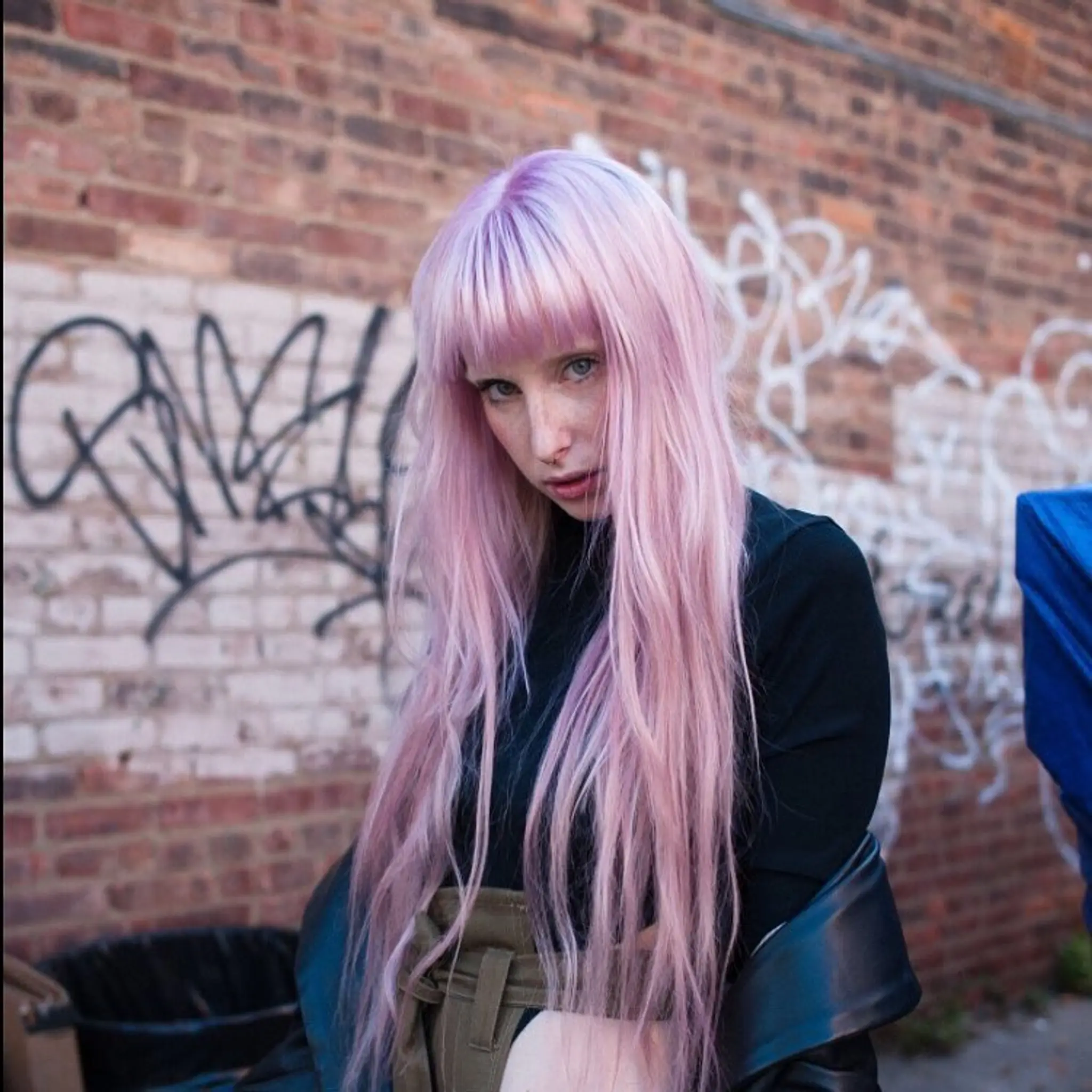 Very long, straight hair with a pastel lavender color and soft, feathered bangs that create a whimsical and ethereal vibe. The length is layered for added movement.