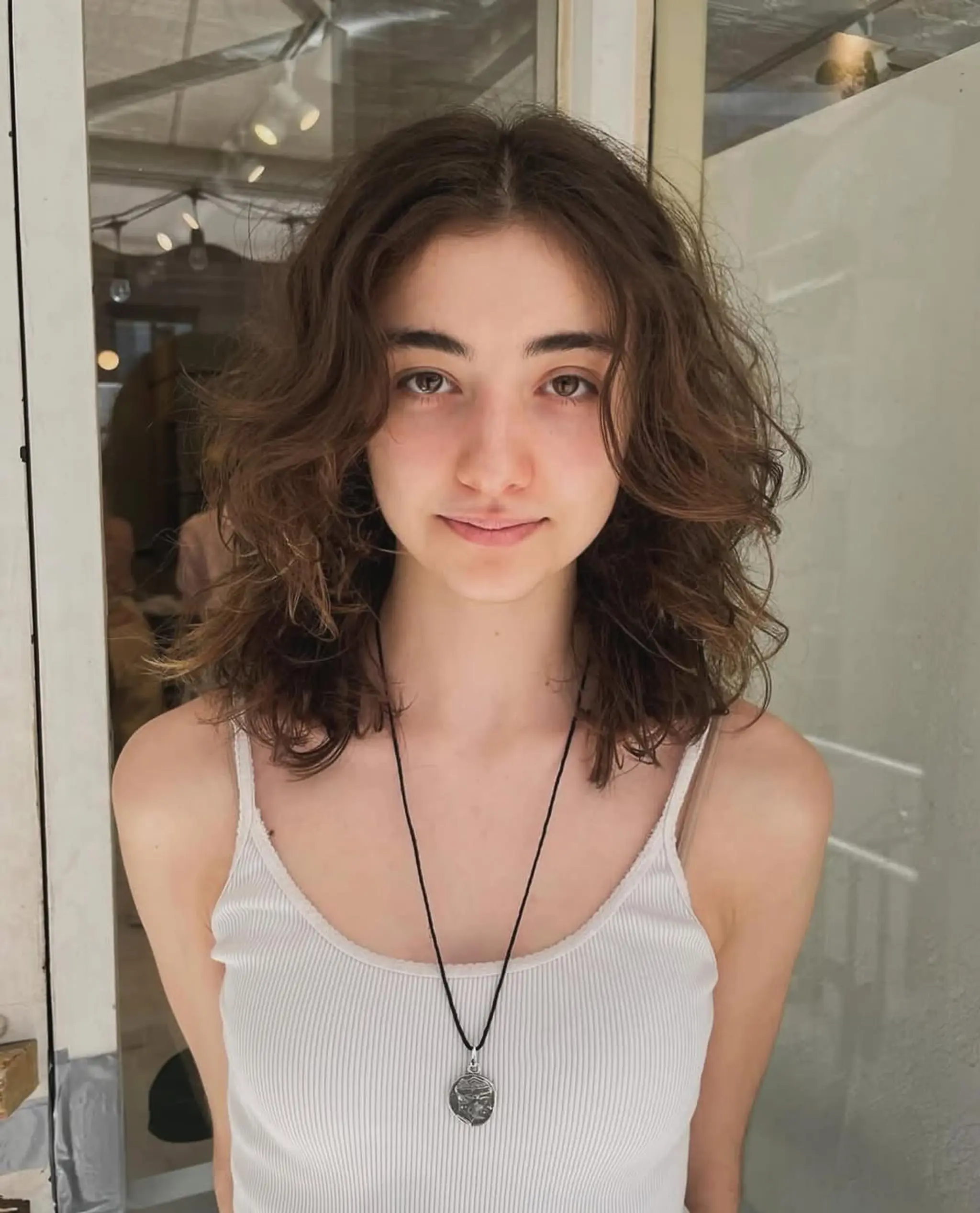Relaxed, medium-length wavy hair with a tousled, layered, and natural look.