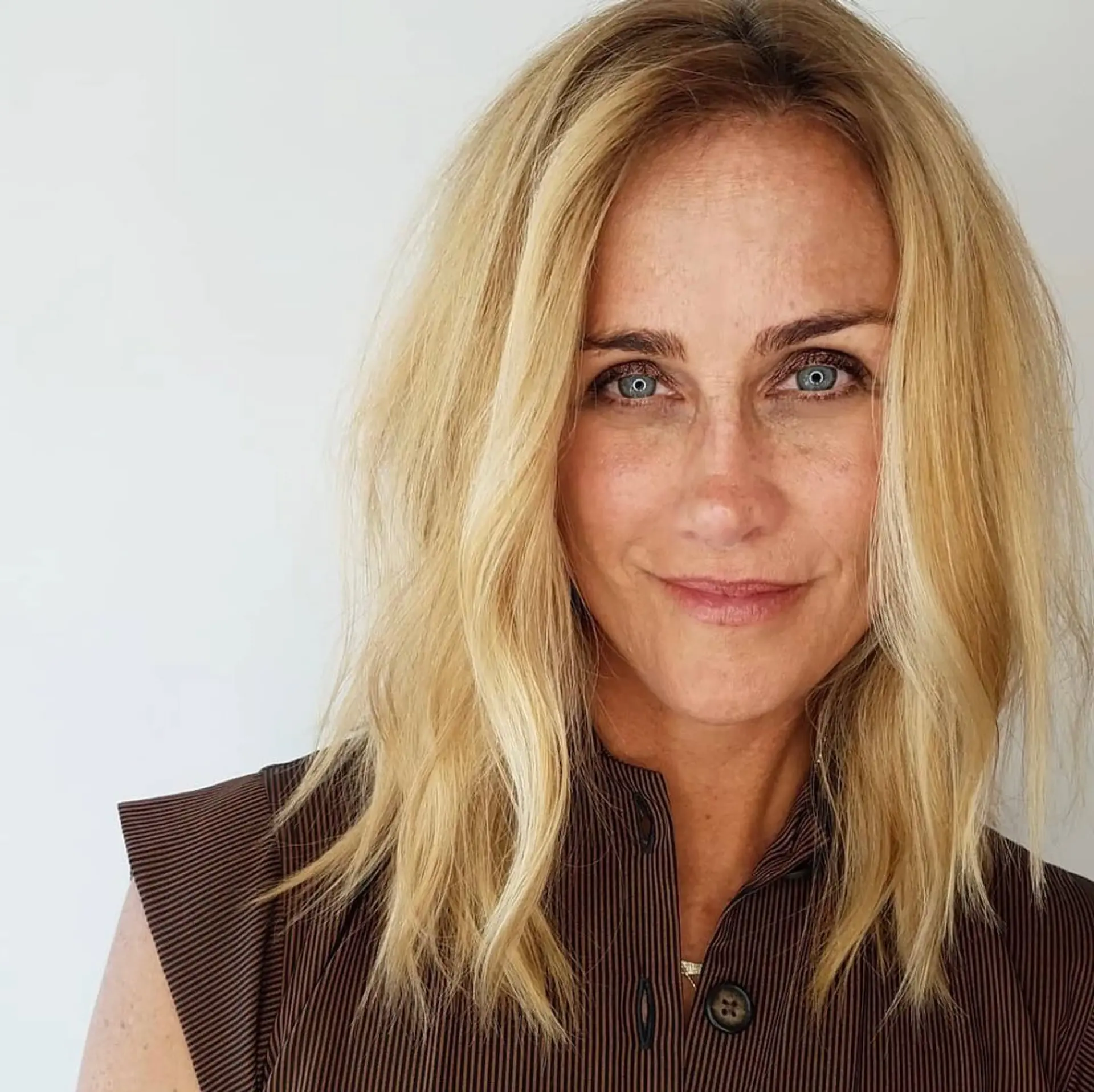 A medium-length textured blonde lob styled with loose, effortless waves and a center part. 1