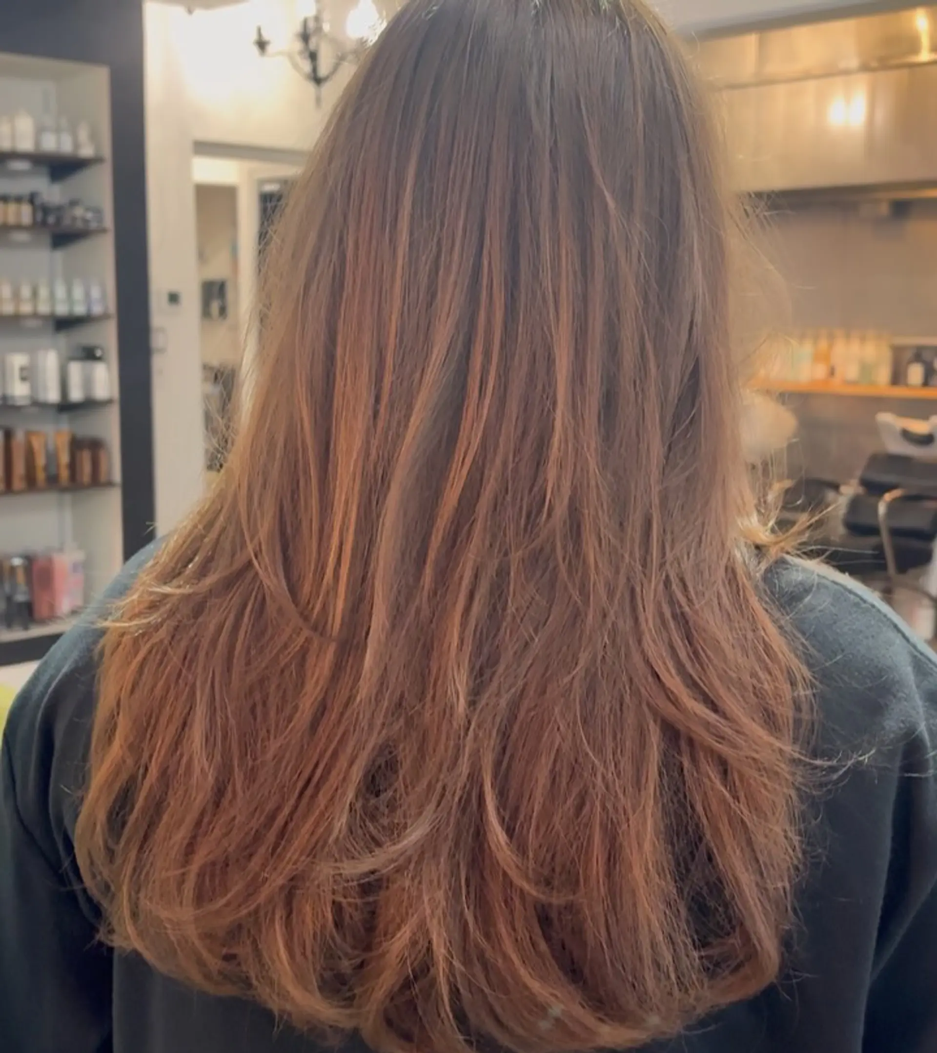 Long warm brown hair cut into flowing textured layers with soft curved ends. 1
