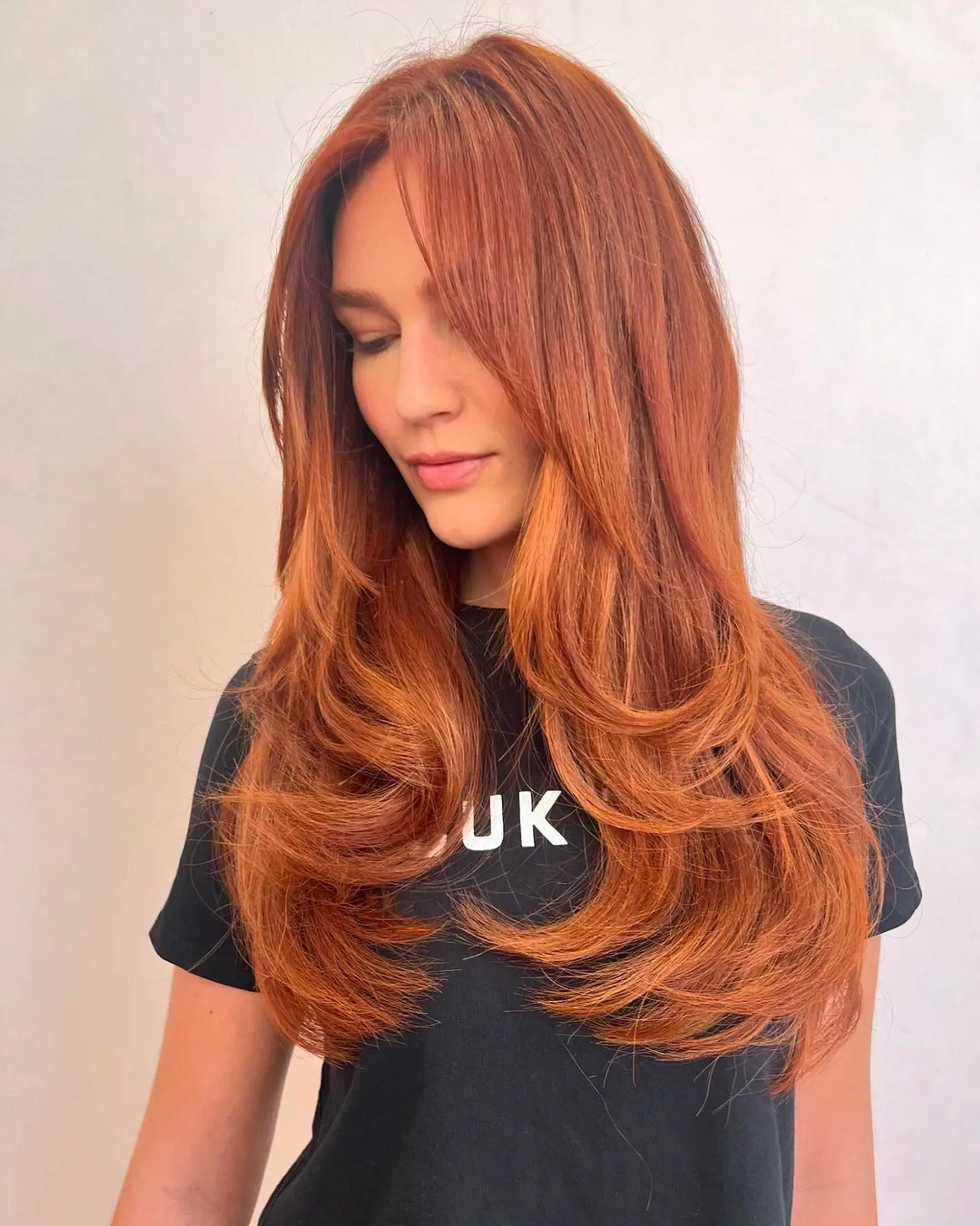 Long, wavy copper hair with side-swept bangs and layered throughout. 1
