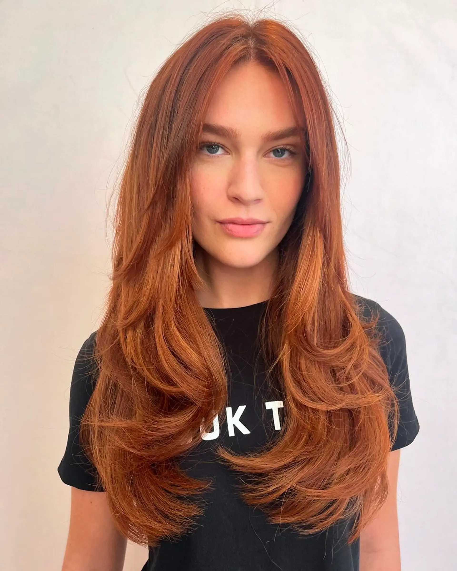 Long, wavy copper hair with side-swept bangs and layered throughout. 2