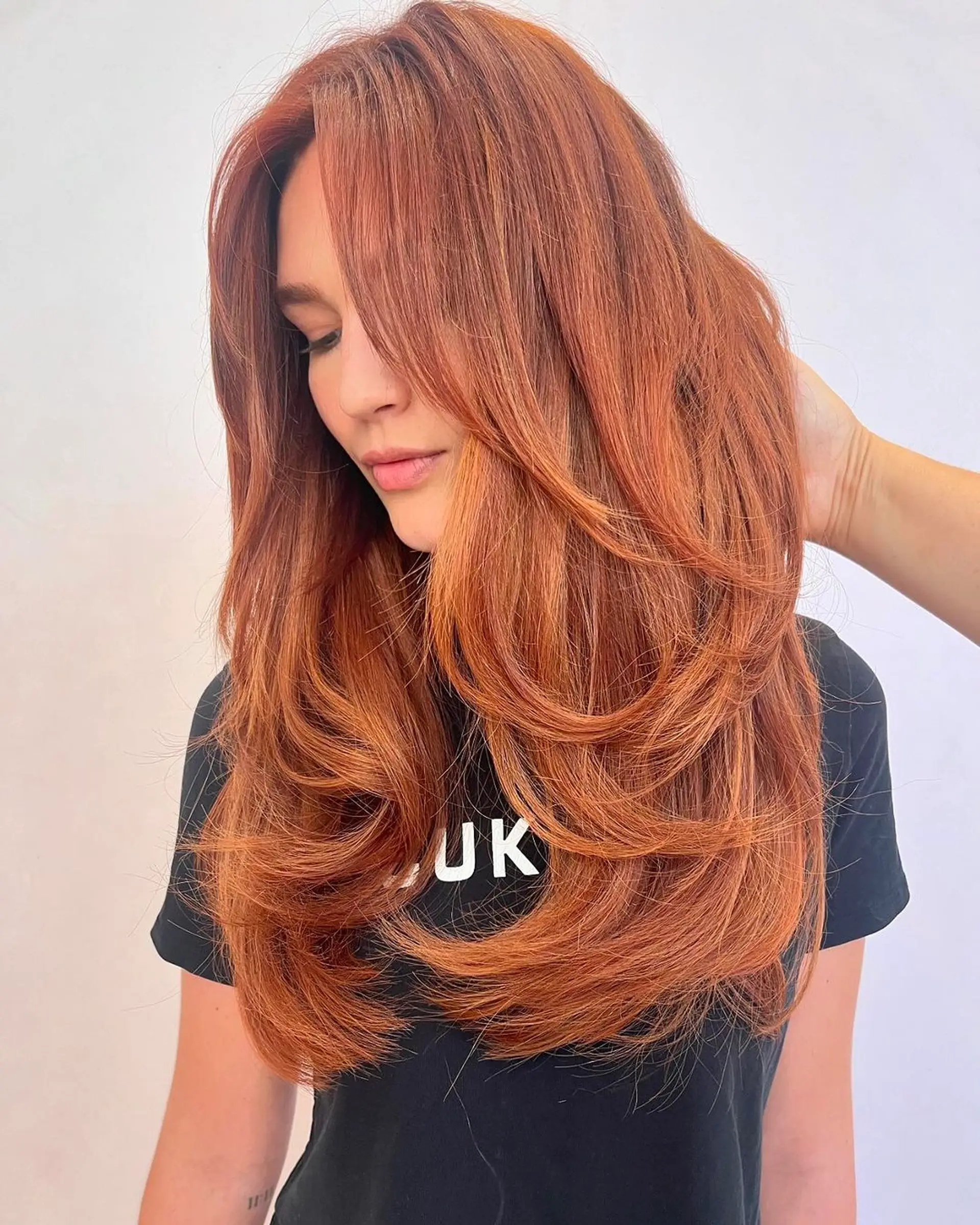 Long, wavy copper hair with side-swept bangs and layered throughout. 3