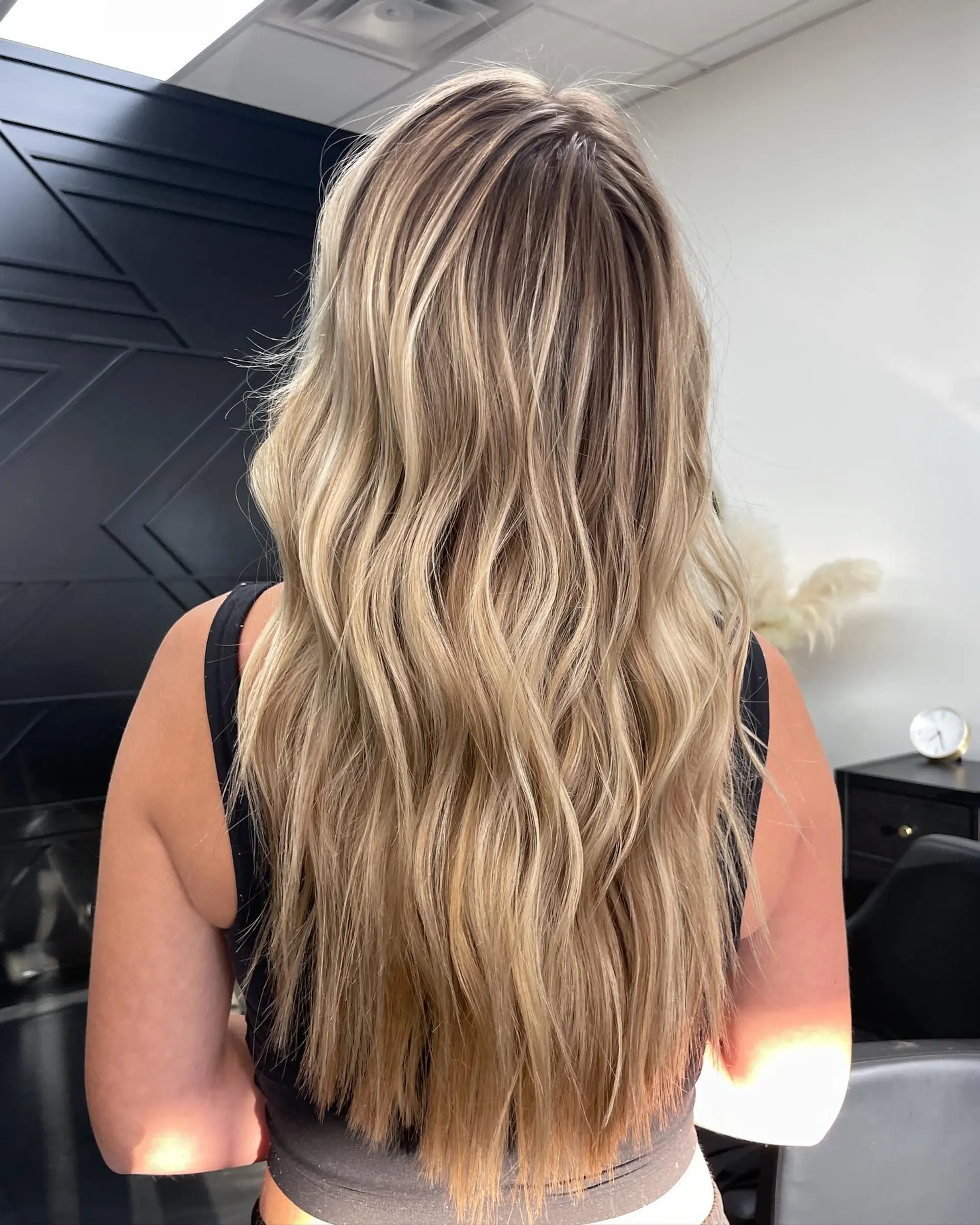 Long multi-tonal blonde hair styled in relaxed, soft waves with natural root blending. 1