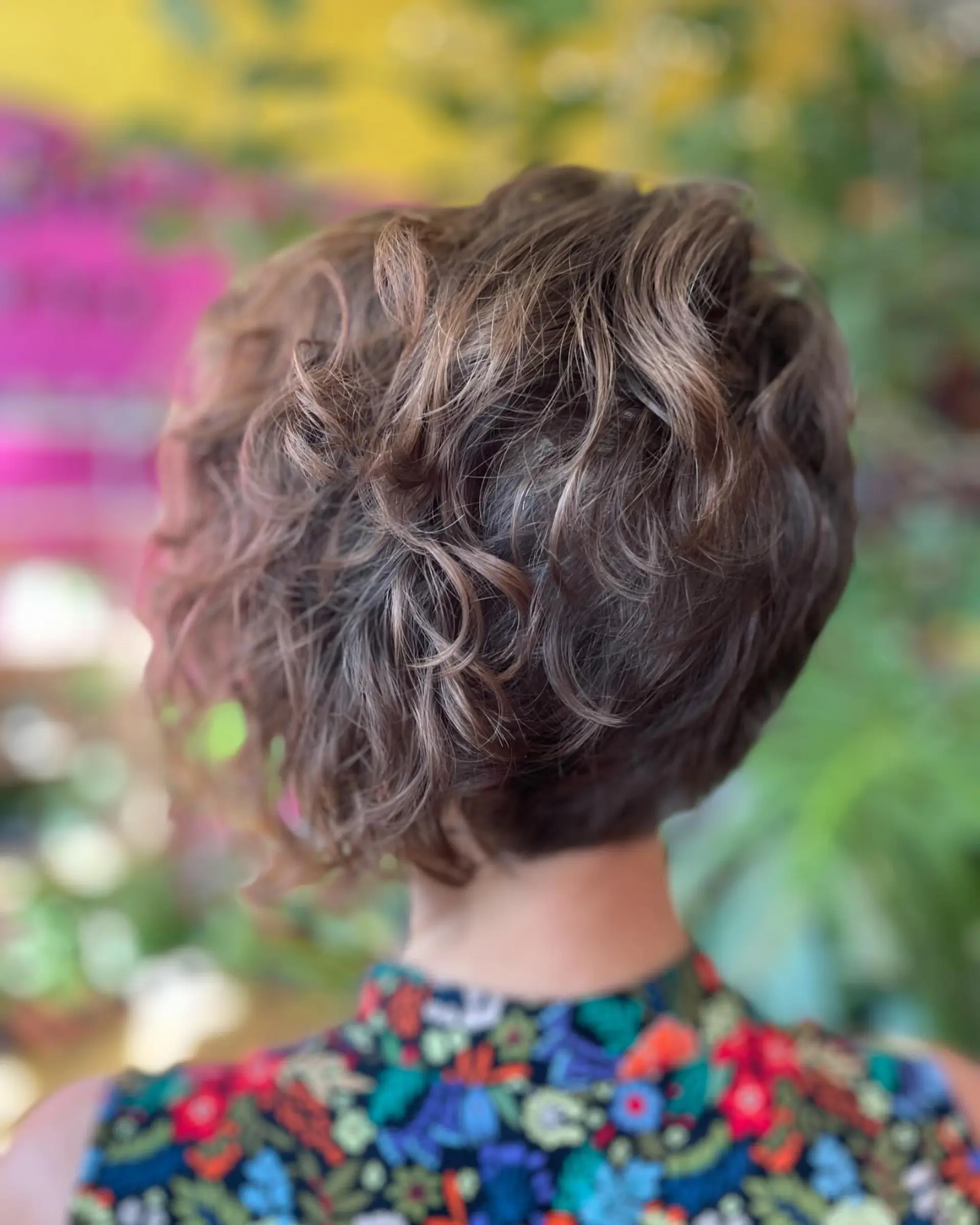 A short, textured asymmetrical bob featuring soft waves and a tapered nape. 1
