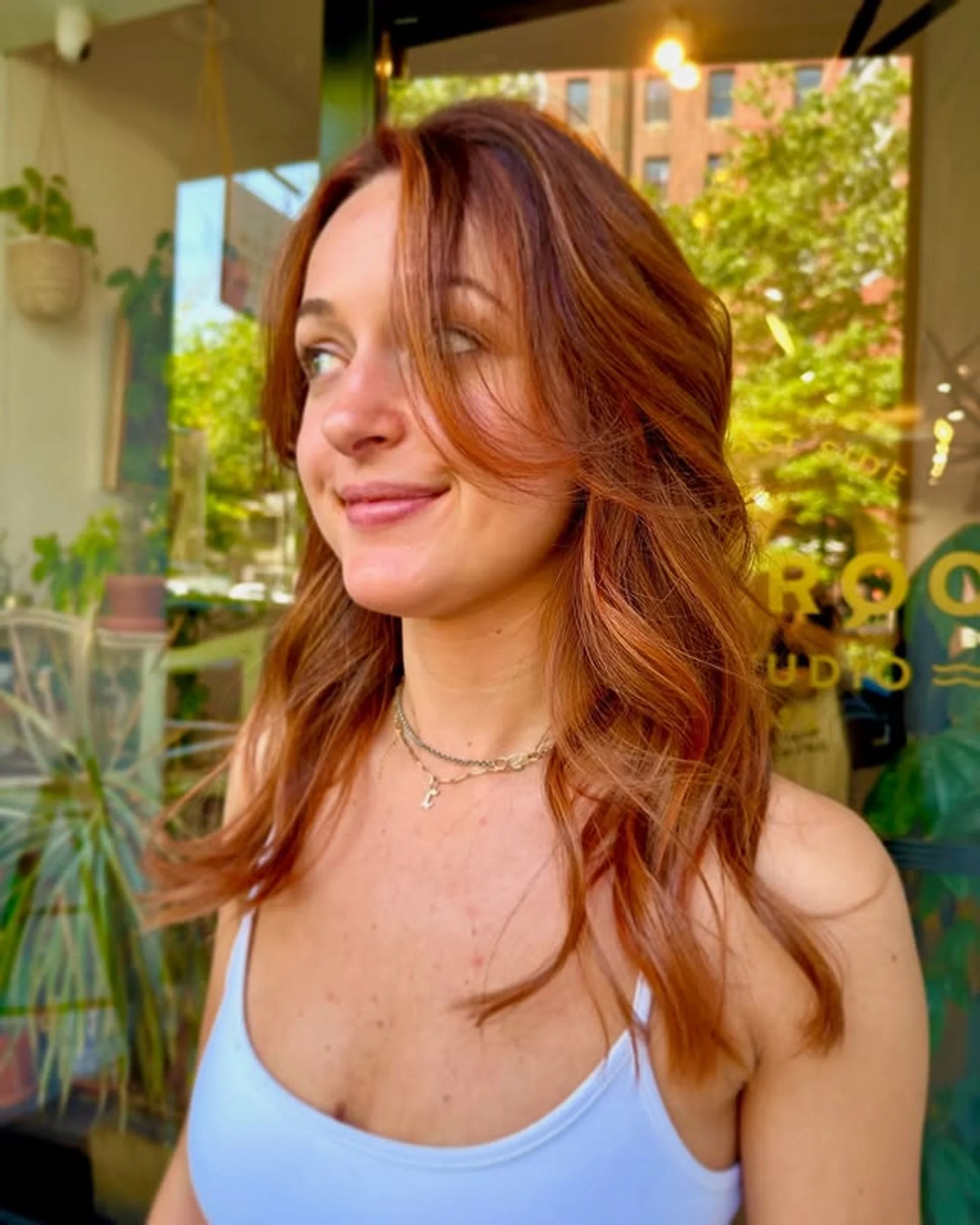 A model with a vibrant copper red curly shag haircut with bangs, showcasing a key 2025 hair color trend. - Preview 1